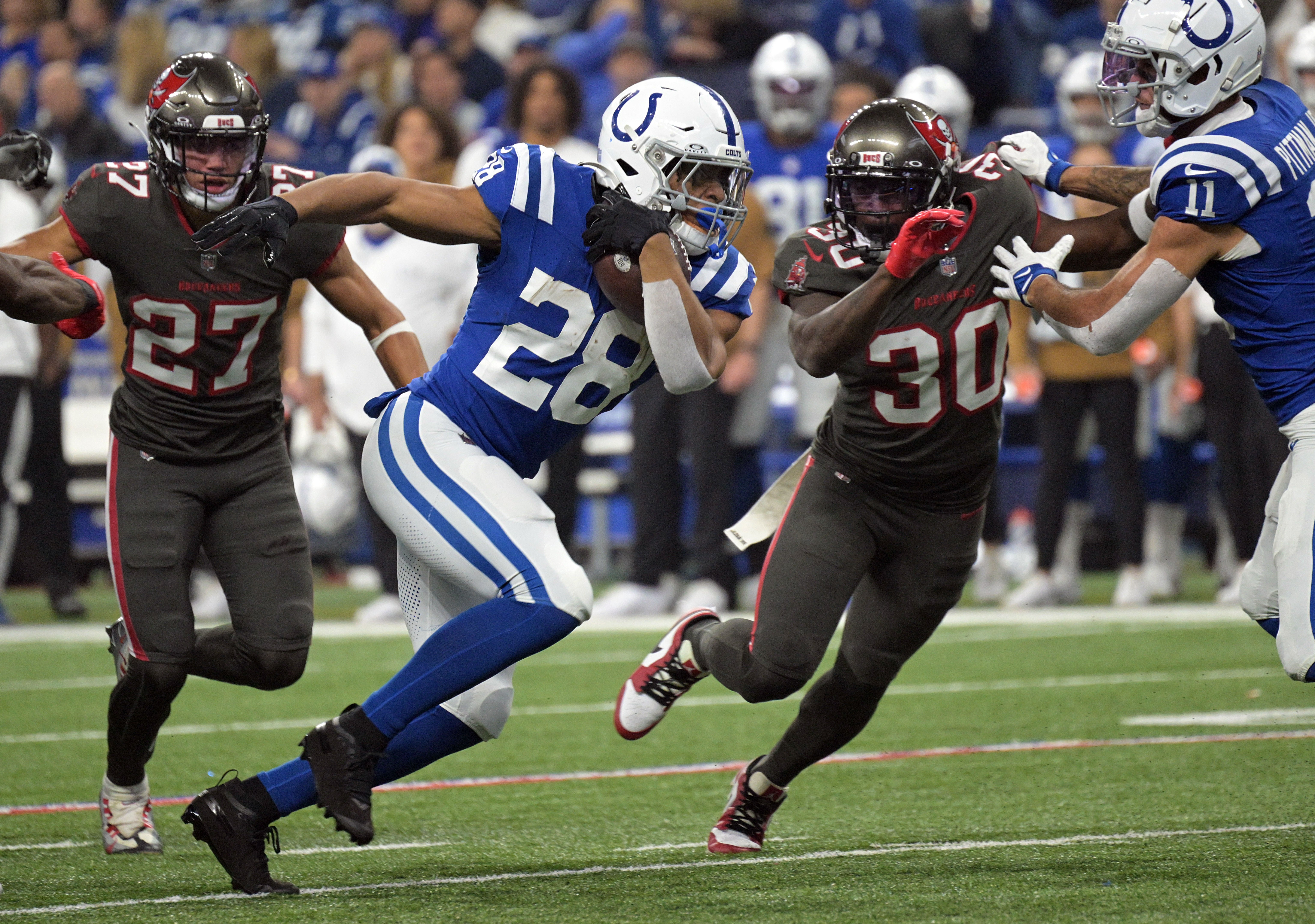 Nov 26, 2023; Indianapolis, Indiana, USA; Indianapolis Colts running back Jonathan Taylor (28) runs to get past Tampa Bay Buccaneers cornerback Dee Delaney (30) during the second quarter at Lucas Oil Stadium.