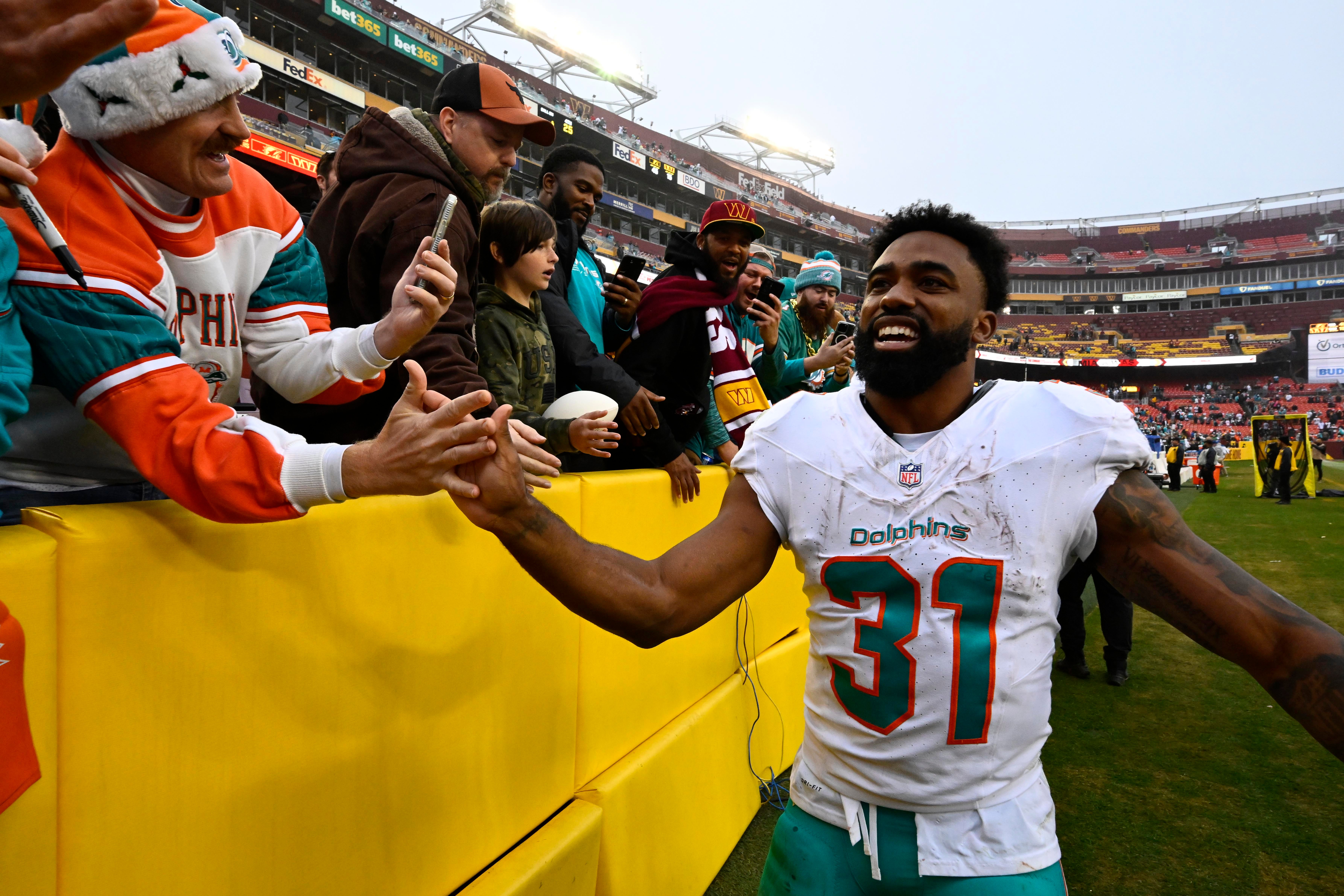 Dec 3, 2023; Landover, Maryland, USA; Miami Dolphins running back Raheem Mostert (31) celebrates with fans after the game against the Washington Commanders at FedExField. Mandatory Credit: Brad Mills-USA TODAY Sports