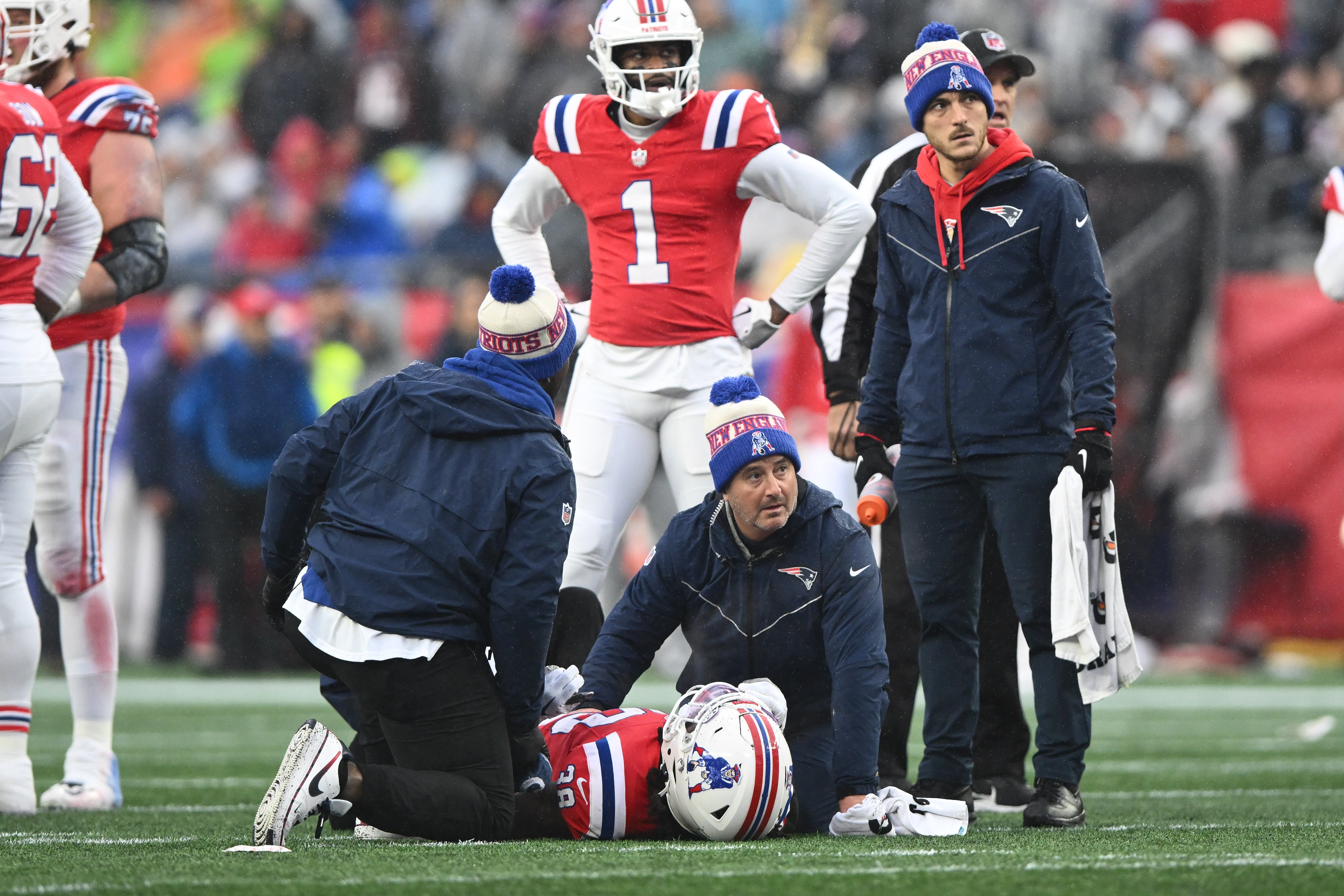 New England Patriots running back Rhamondre Stevenson is helped by the athletic staff after an injury on a play against the Los Angeles Chargers during the first half at Gillette Stadium.