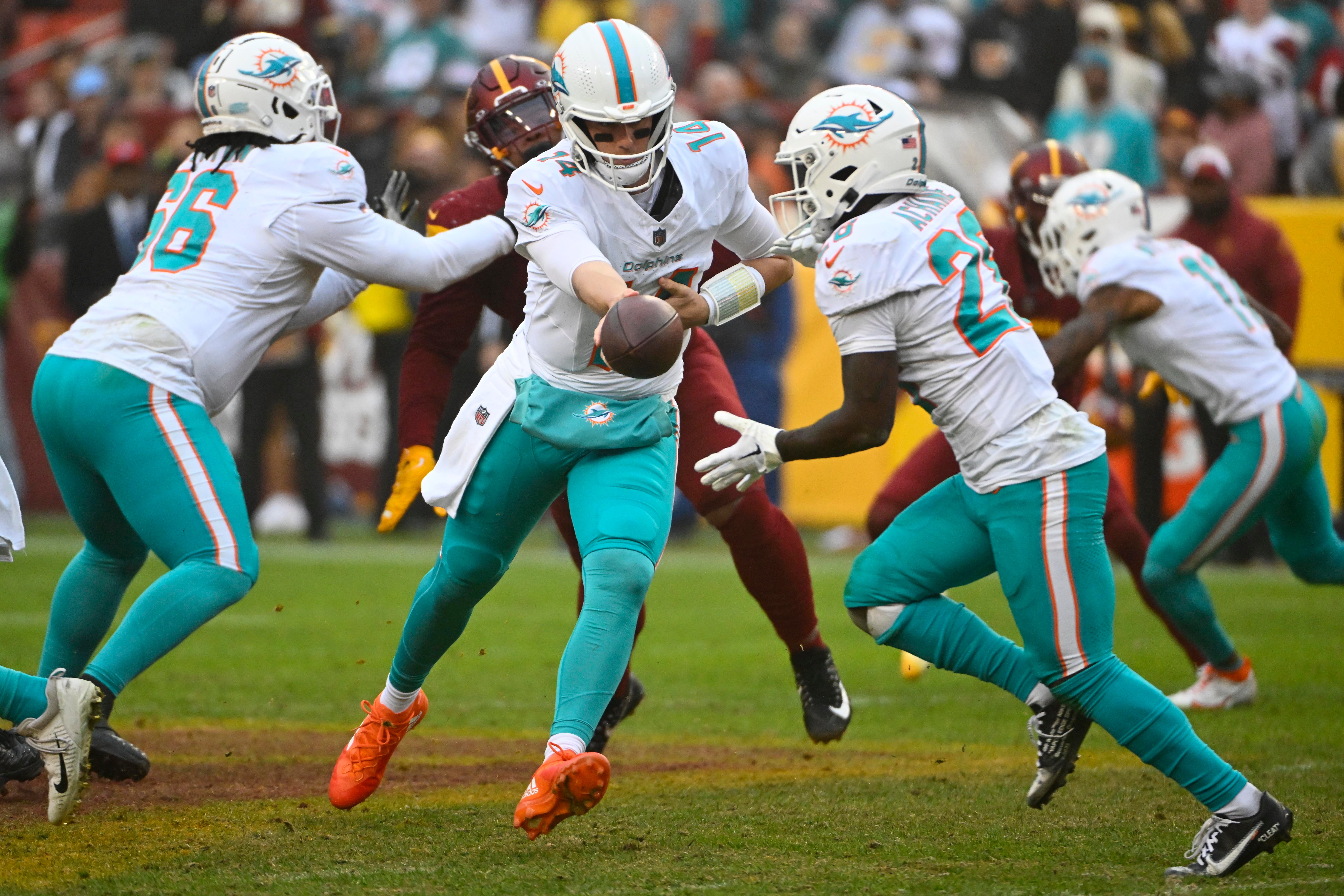 Dec 3, 2023; Landover, Maryland, USA; Miami Dolphins quarterback Mike White (14) hands off to running back De'Von Achane (28) against the Washington Commanders during the second half at FedExField. Mandatory Credit: Brad Mills-USA TODAY Sports