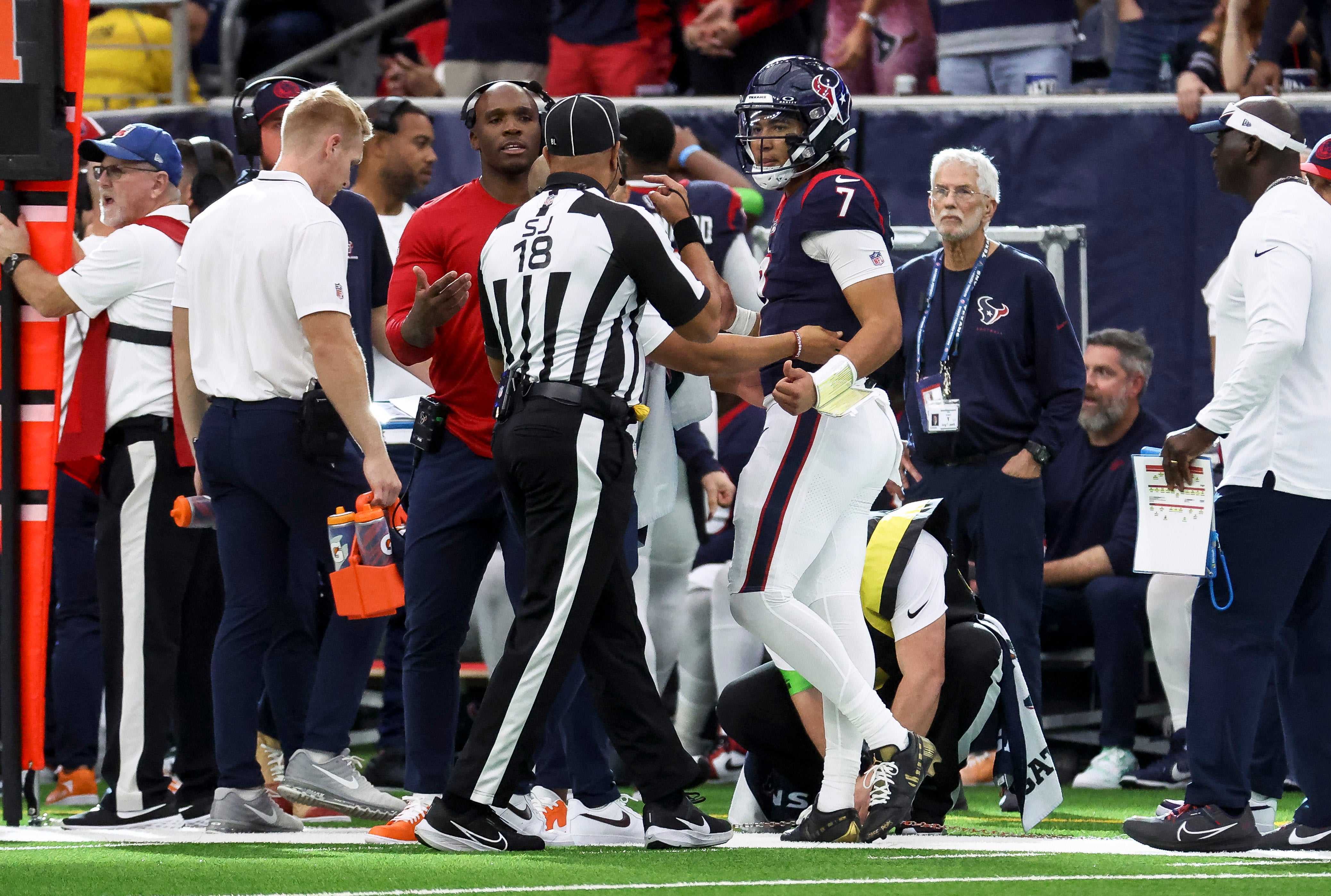 Dec 3, 2023; Houston, Texas, USA; Houston Texans quarterback C.J. Stroud (7) walks off the field with an official during the fourth quarter against the Denver Broncos at NRG Stadium.