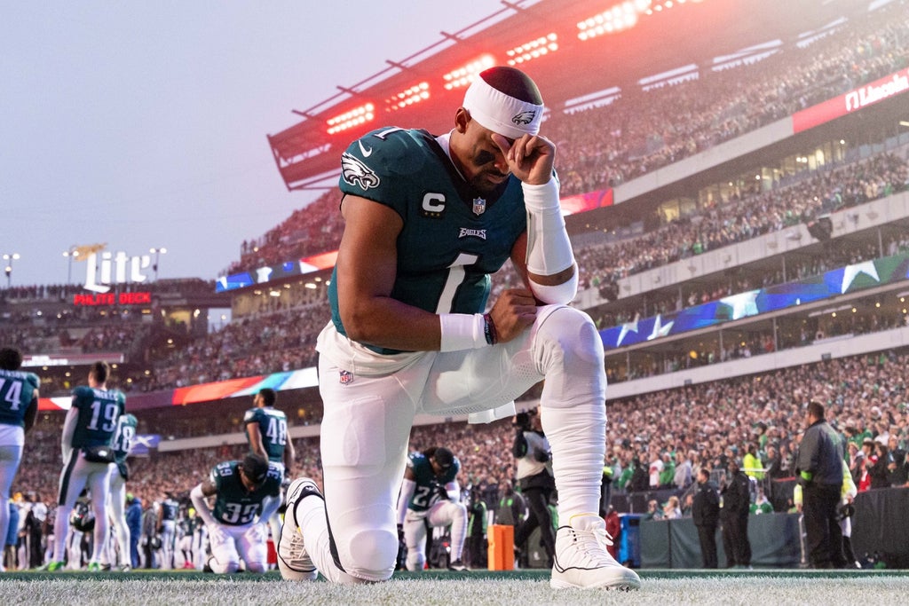 Philadelphia Eagles quarterback Jalen Hurts kneels before the start of a game against the San Francisco 49ers at Lincoln Financial Field.