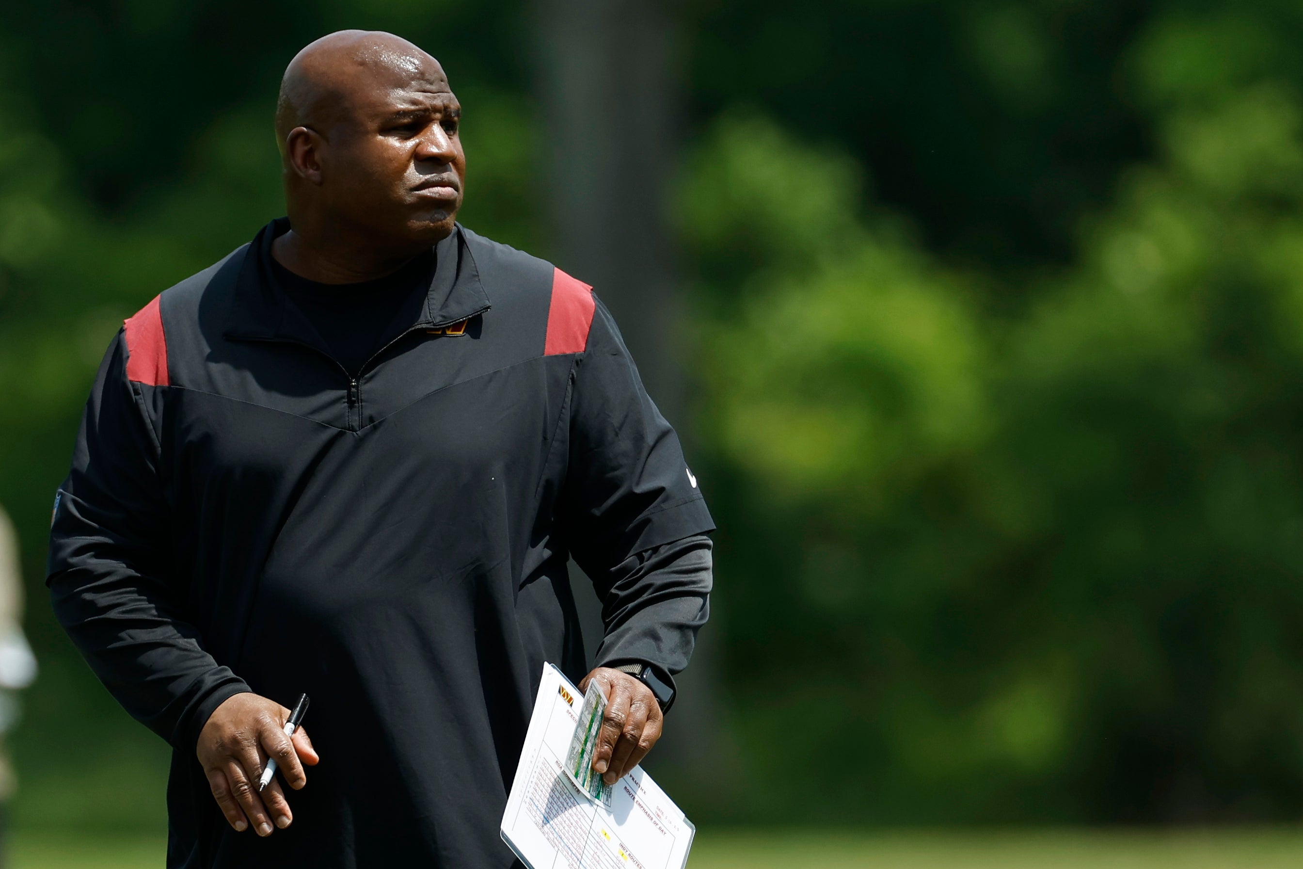 May 12, 2023; Ashburn, VA, USA; Washington Commanders assistant head coach/offensive coordinator Eric Bieniemy stands on the field during Commanders rookie minicamp at Commanders Park.