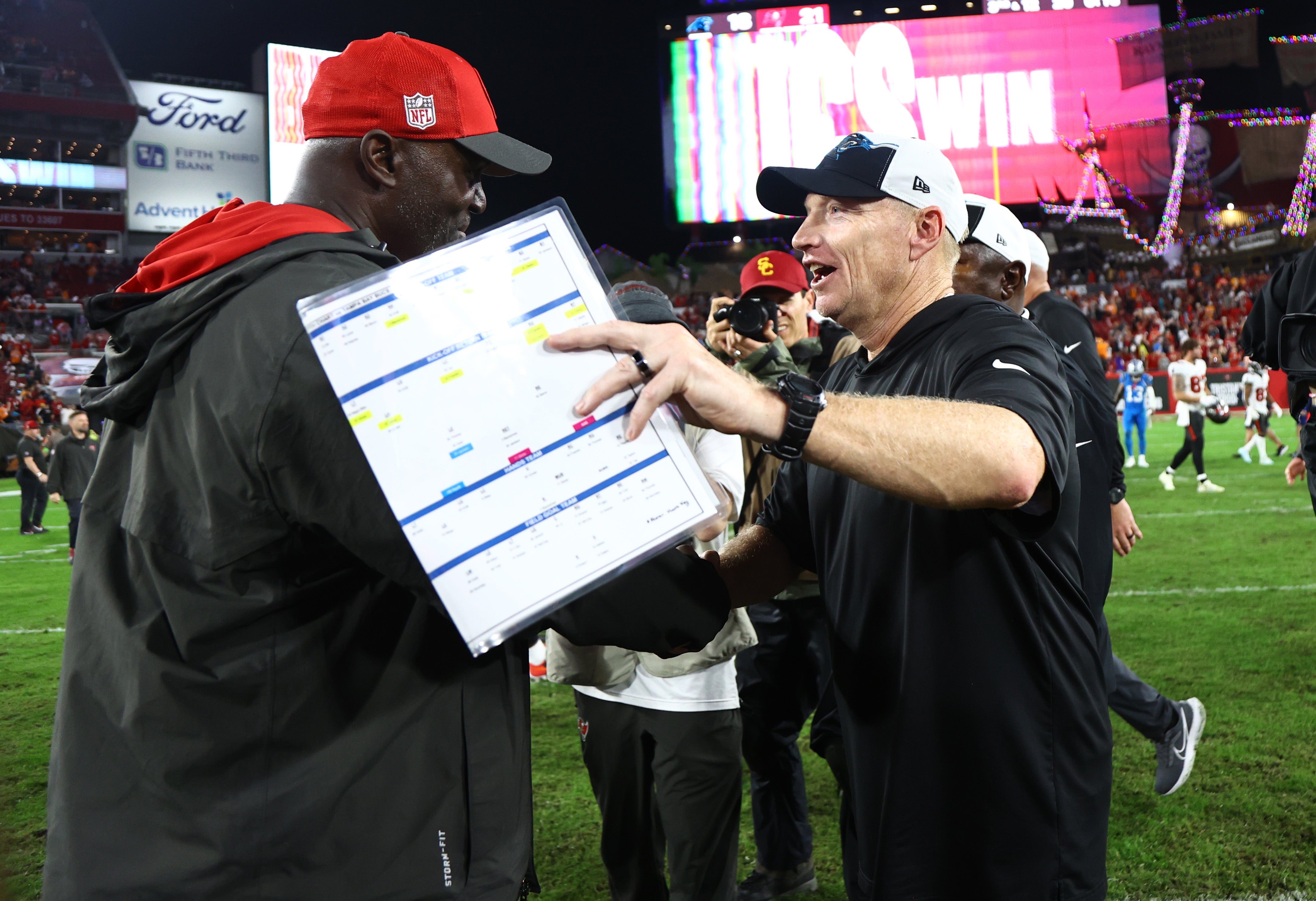 Dec 3, 2023; Tampa, Florida, USA; Tampa Bay Buccaneers head coach Todd Bowles and Carolina Panthers interim head coach Chris Tabor greet after the game at Raymond James Stadium. Mandatory Credit: Kim Klement Neitzel-USA TODAY Sports