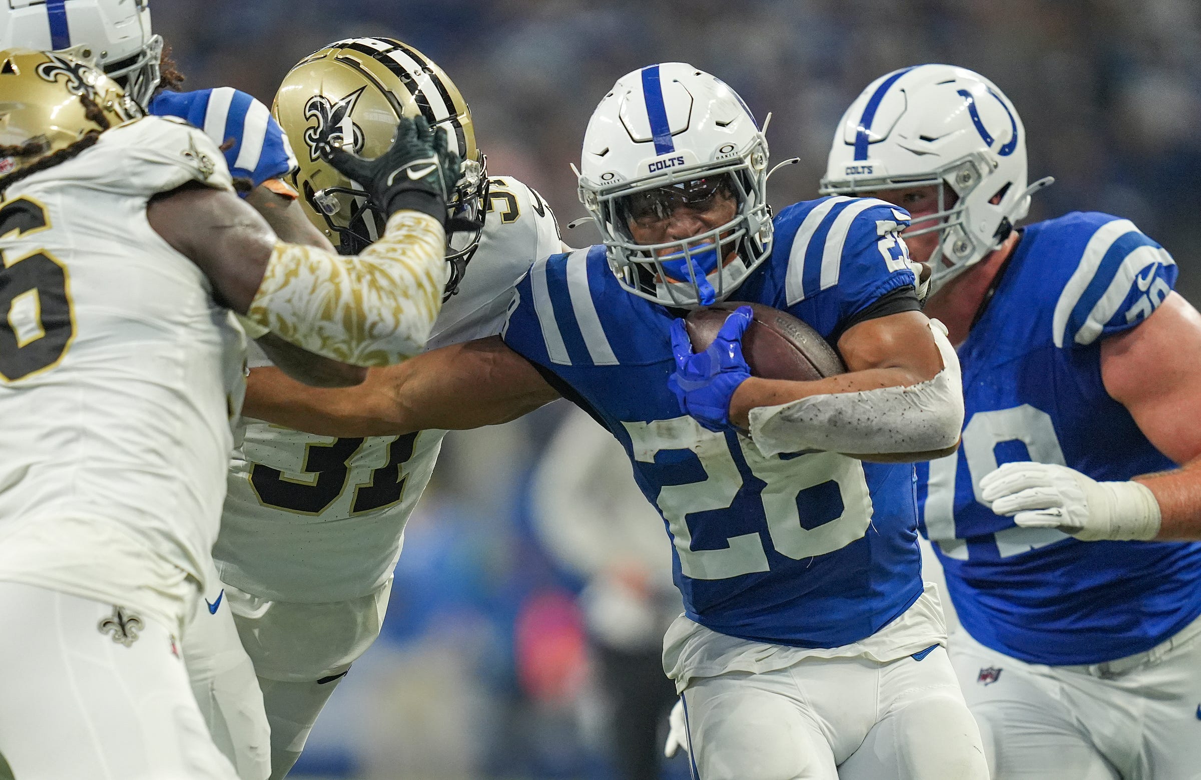 Indianapolis Colts running back Jonathan Taylor (28) evades New Orleans Saints defenders Sunday, Oct. 29, 2023, at Lucas Oil Stadium in Indianapolis.