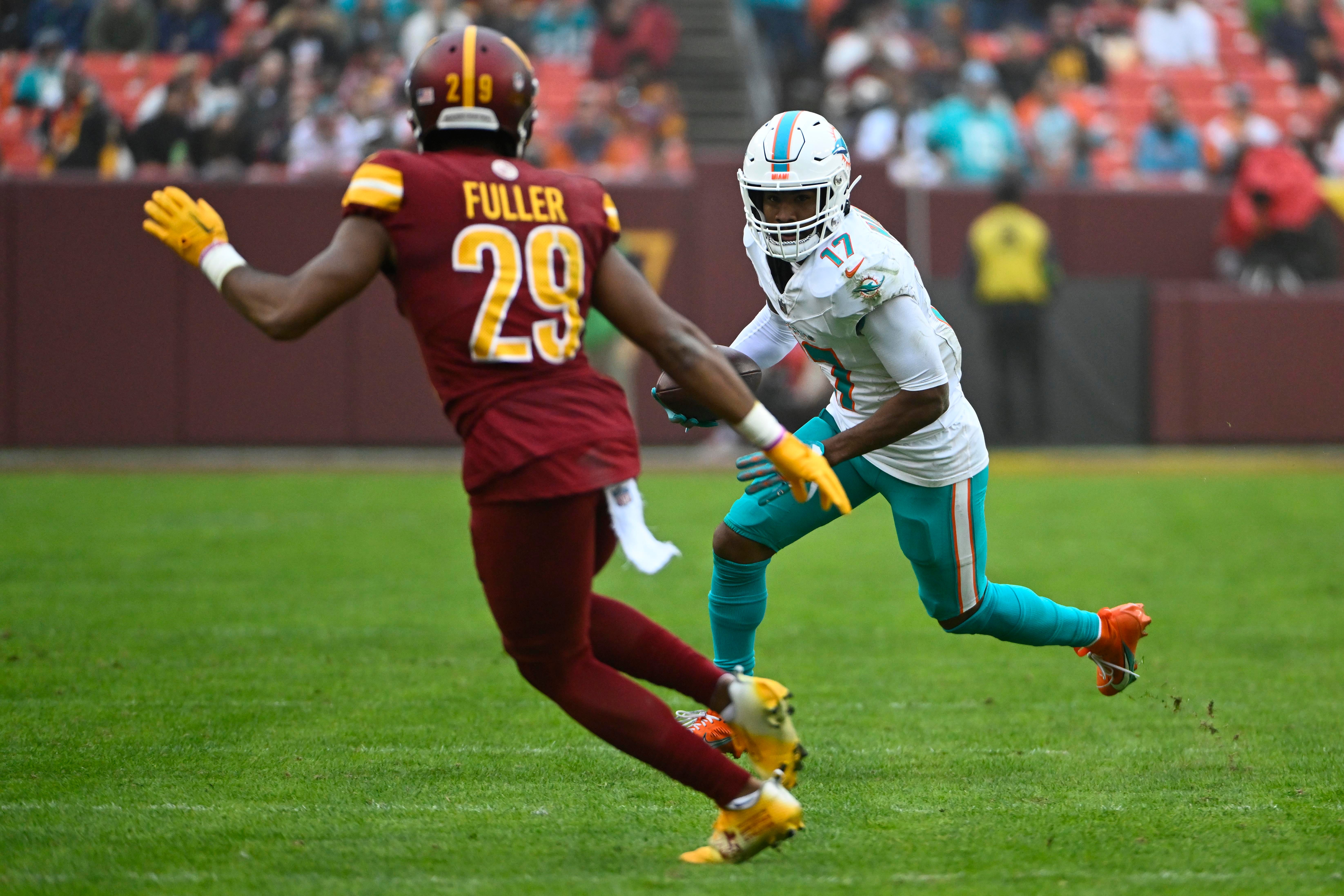 Dec 3, 2023; Landover, Maryland, USA; Miami Dolphins wide receiver Jaylen Waddle (17) runs after a catch as Washington Commanders cornerback Kendall Fuller (29) looks on during the second half at FedExField. Mandatory Credit: Brad Mills-USA TODAY Sports