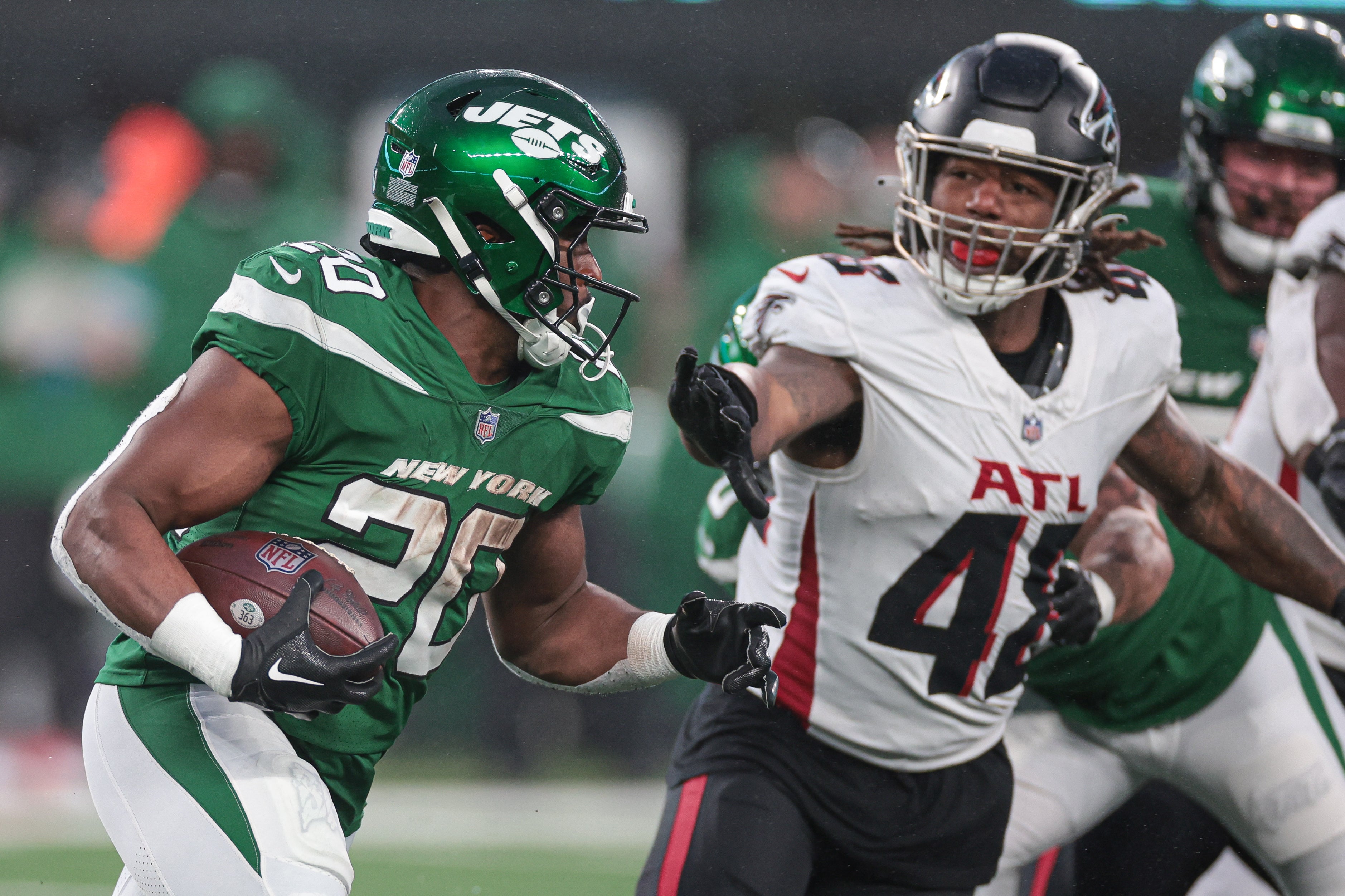 New York Jets running back Breece Hall carries the ball as Atlanta Falcons linebacker Bud Dupree pursues during the second half at MetLife Stadium