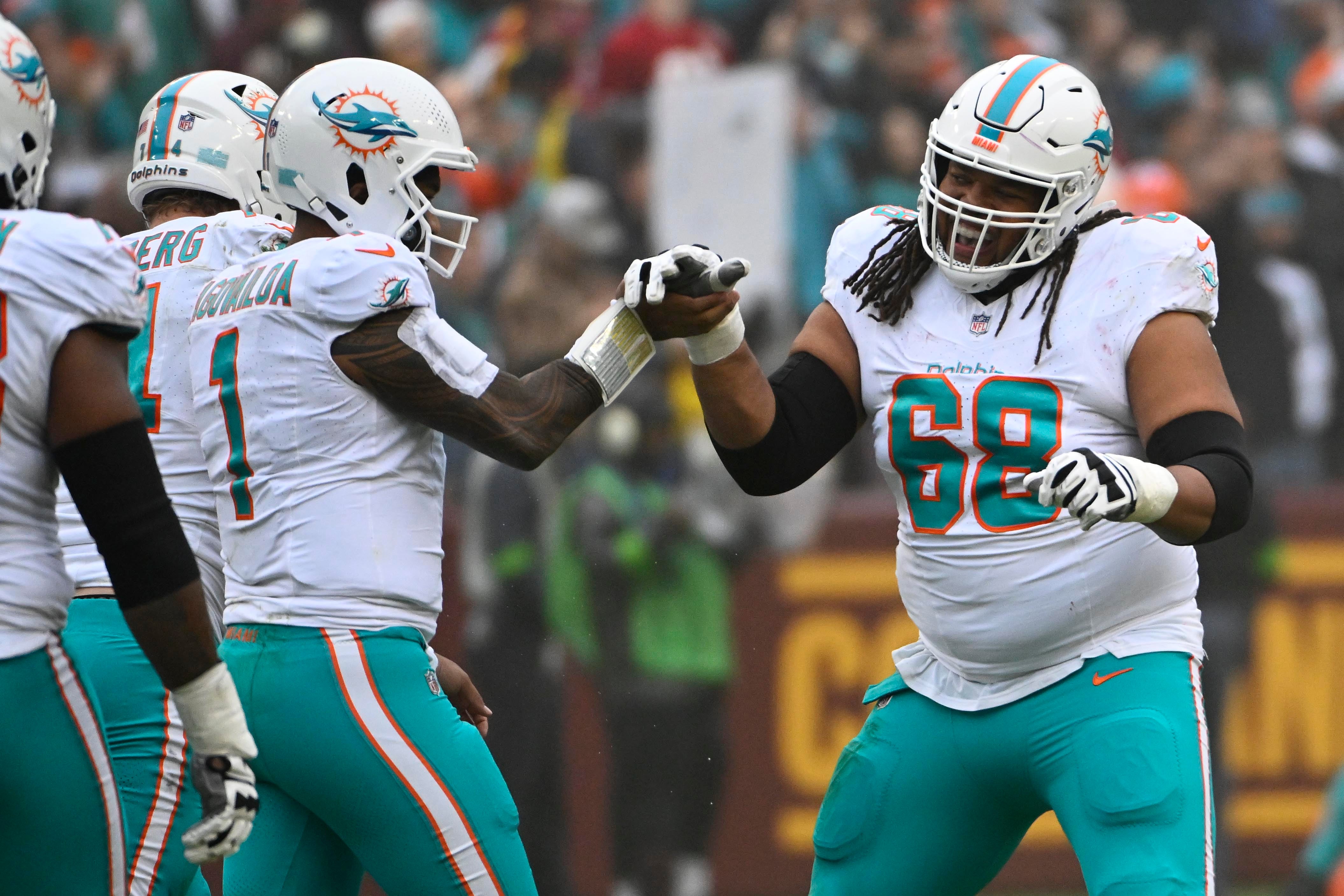 Dec 3, 2023; Landover, Maryland, USA; Miami Dolphins quarterback Tua Tagovailoa (1) celebrates with offensive tackle Robert Hunt (68) after a touchdown pass against the Washington Commanders during the first half at FedExField. Mandatory Credit: Brad Mills-USA TODAY Sports