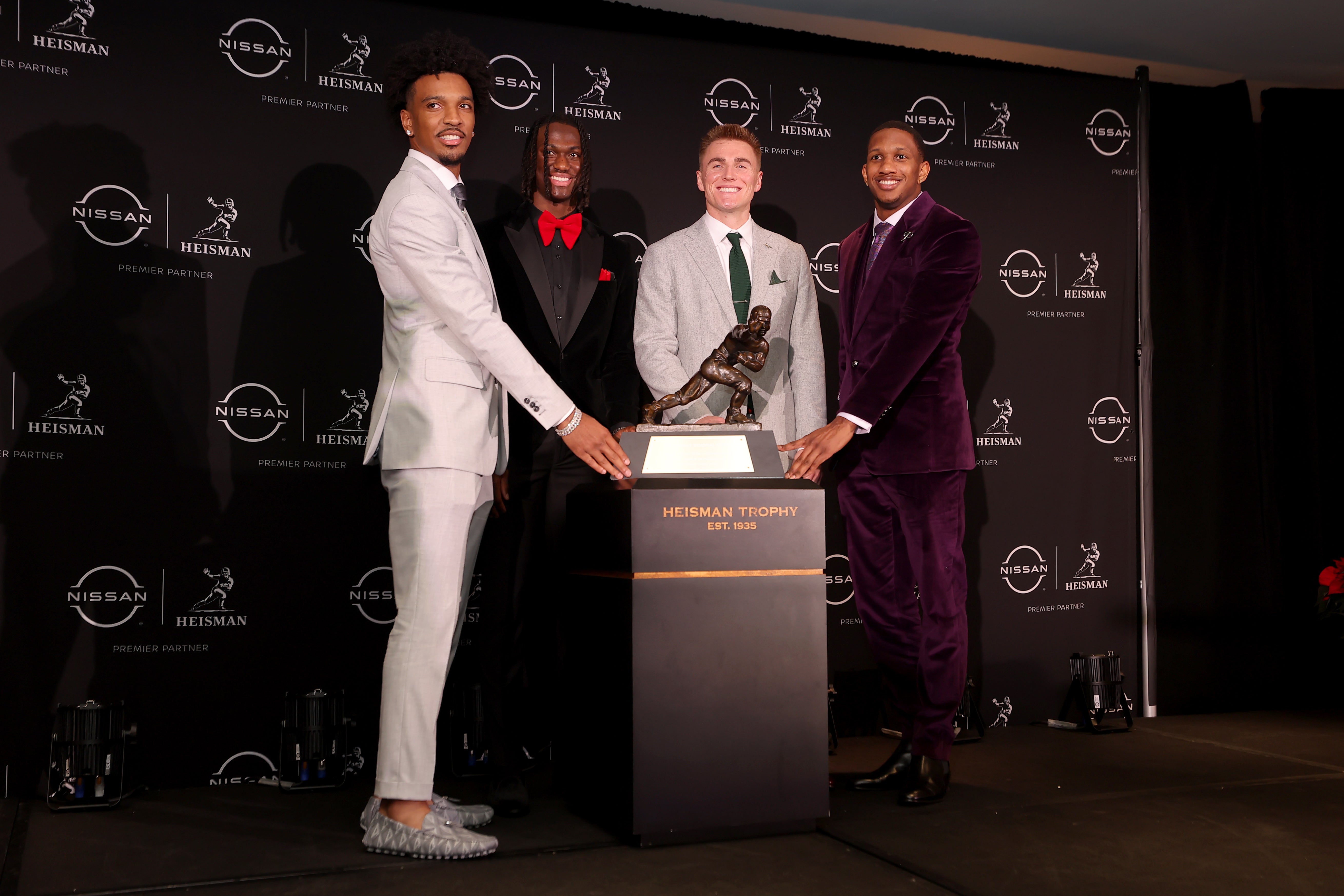 Heisman hopefuls LSU Tigers quarterback Jayden Daniels and Ohio State Buckeyes wide receiver Marvin Harrison Jr. and Oregon Ducks quarterback Bo Nix and Washington Huskies quarterback Michael Penix Jr. pose with the Heisman trophy during a press conference in the Astor ballroom at the New York Marriott Marquis before the presentation of the Heisman trophy