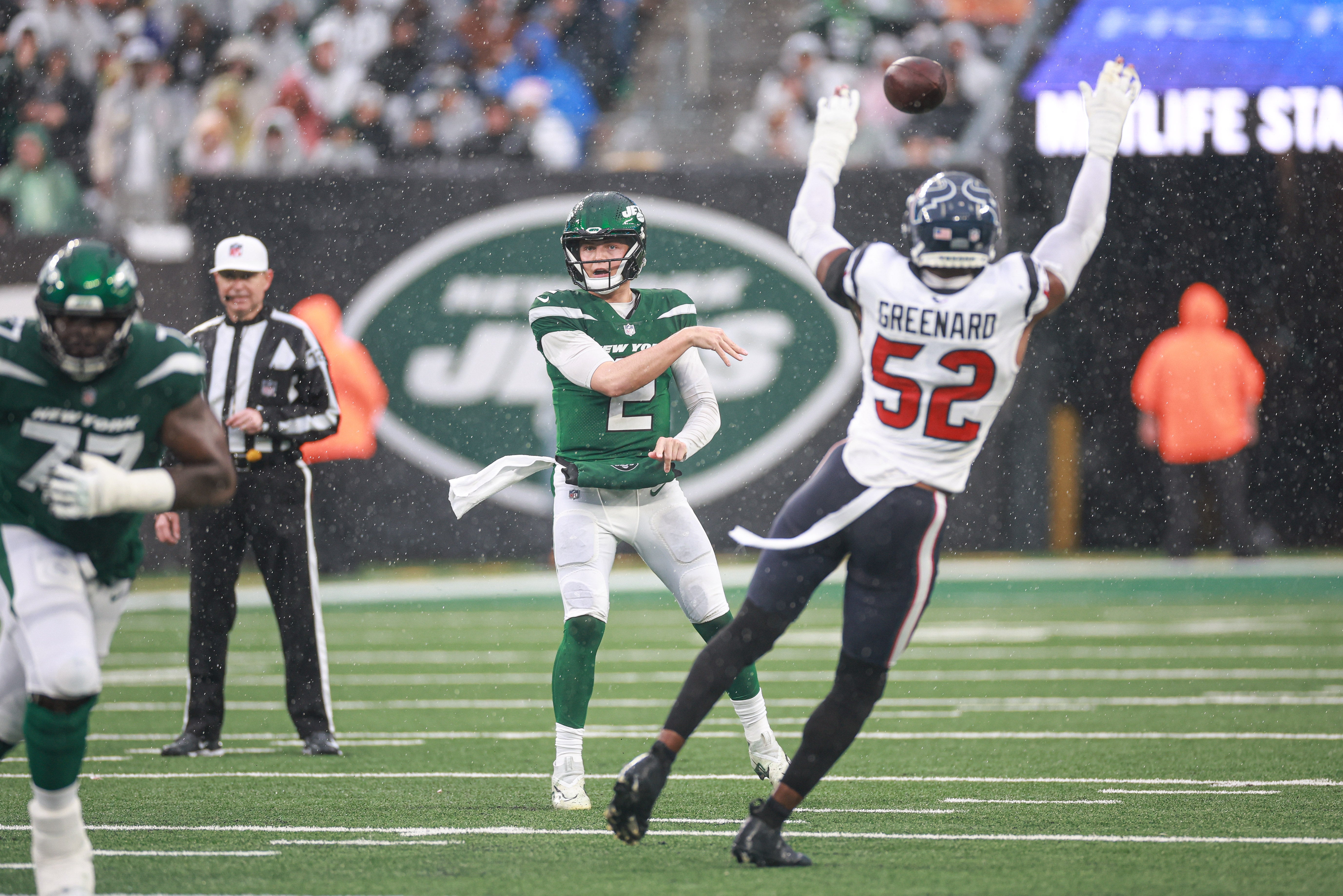 New York Jets quarterback Zach Wilson (2) throws the ball as Houston Texans defensive end Jonathan Greenard (52) defends during the first half at MetLife Stadium.
