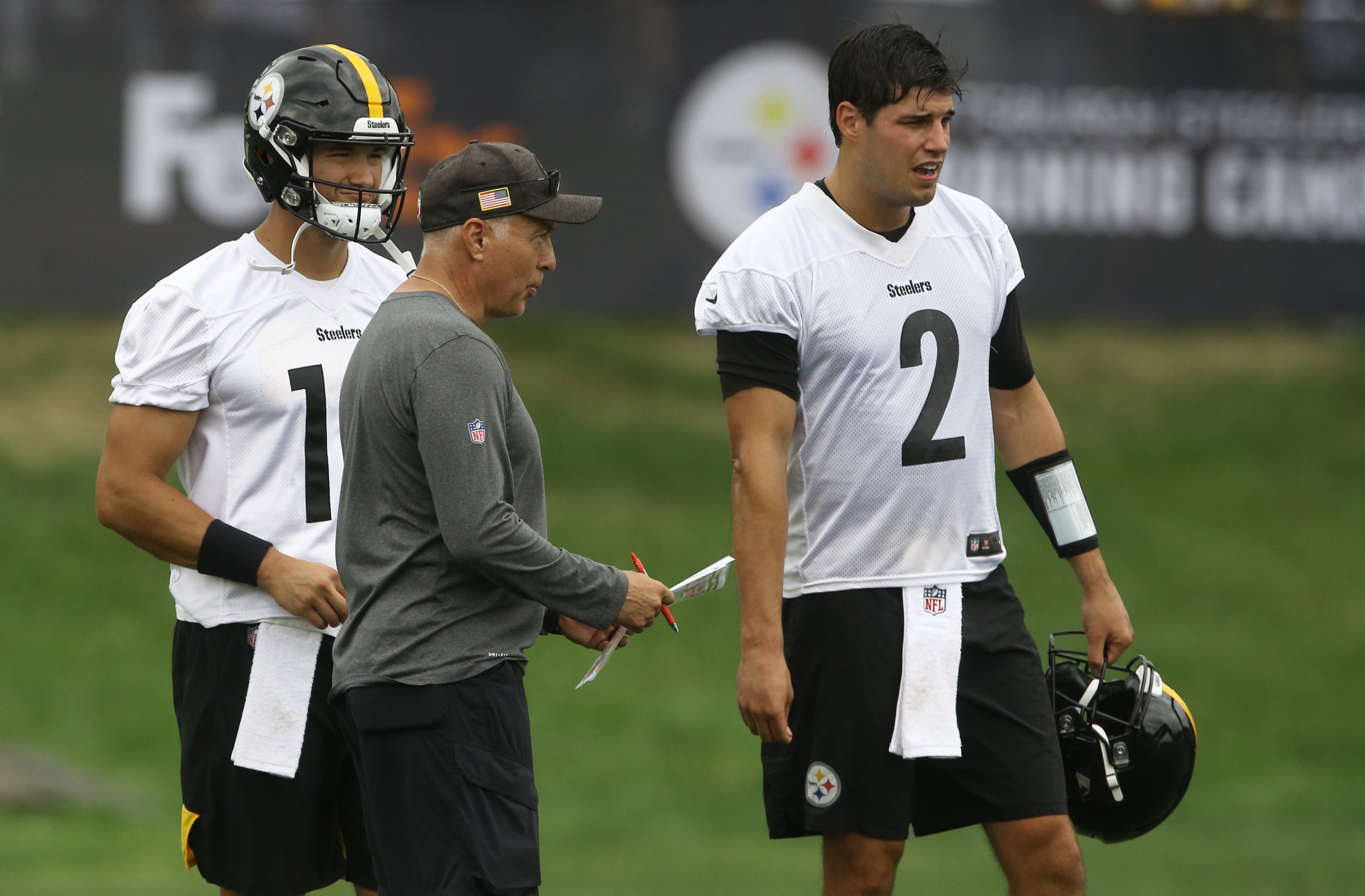 Jul 27, 2022; Latrobe, PA, USA; Pittsburgh Steelers quarterbacks coach Mike Sullivan (front) talks with quarterbacks Mitch Trubisky (10) and Mason Rudolph (2) during training camp at Chuck Noll Field. Mandatory Credit: Charles LeClaire-USA TODAY Sports  