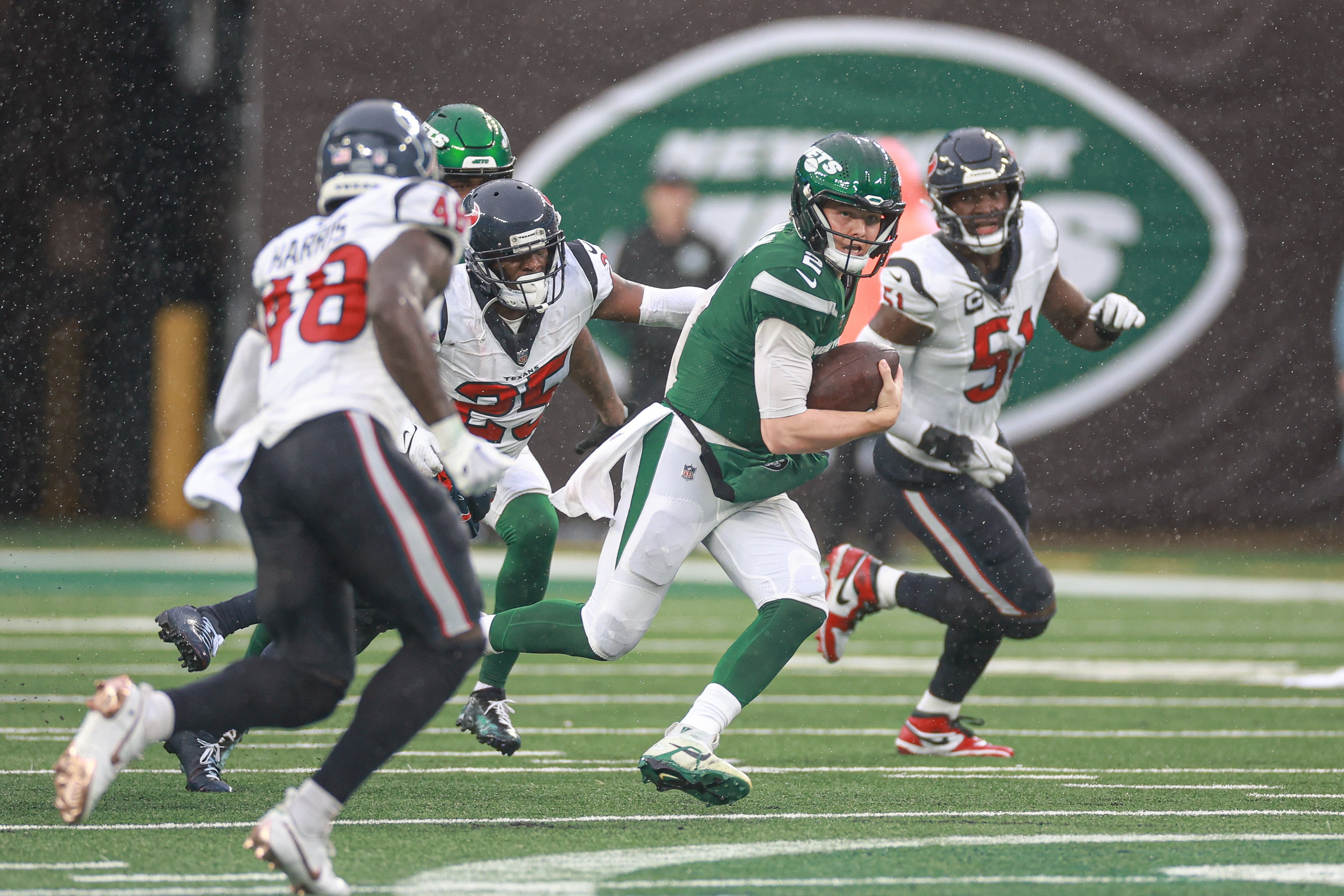 New York Jets quarterback Zach Wilson (2) is pursued by Houston Texans cornerback Desmond King II (25) during the second half at MetLife Stadium.