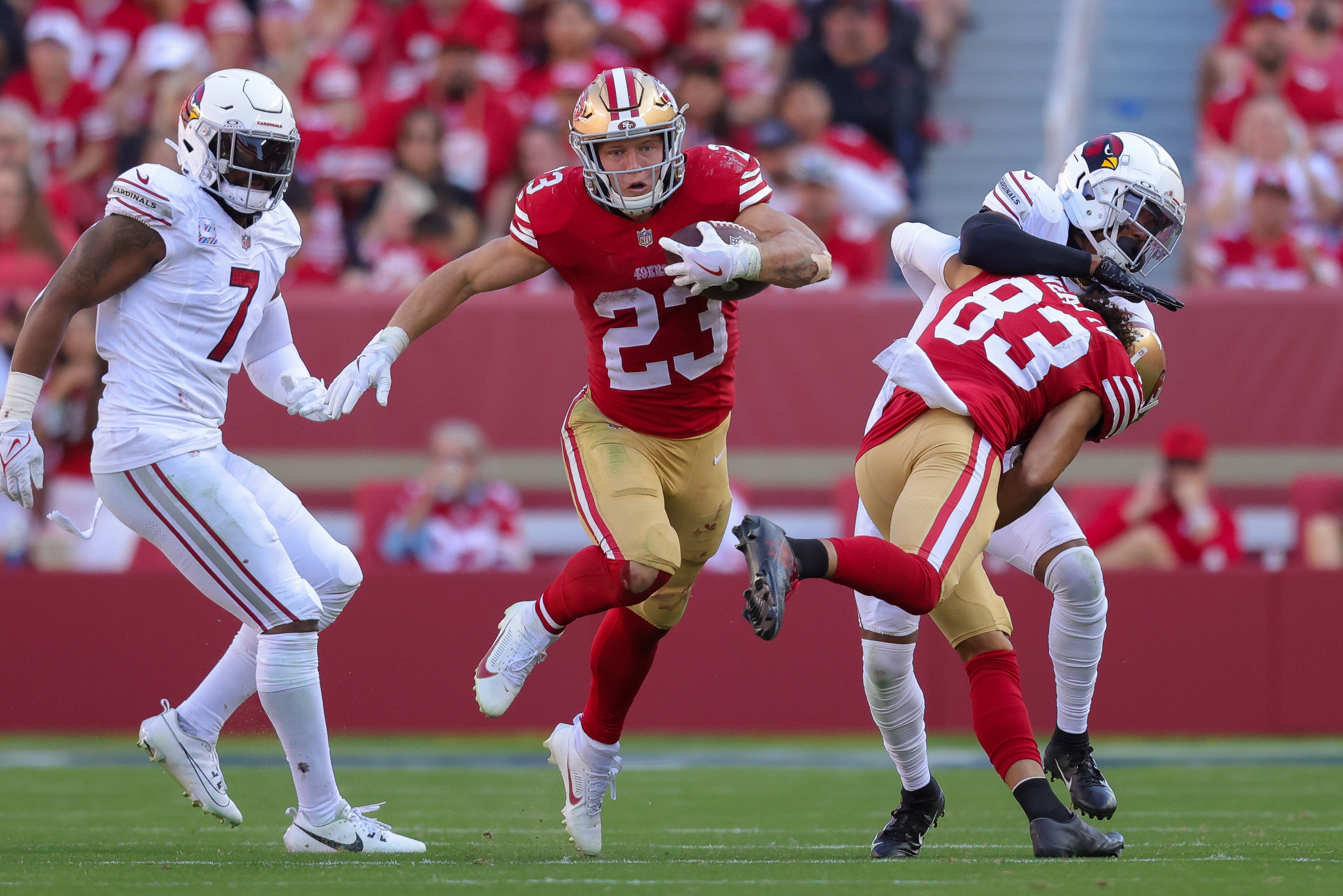 Oct 1, 2023; Santa Clara, California, USA; San Francisco 49ers running back Christian McCaffrey (23) runs with the ball past Arizona Cardinals linebacker Kyzir White (7) during the fourth quarter at Levi's Stadium.