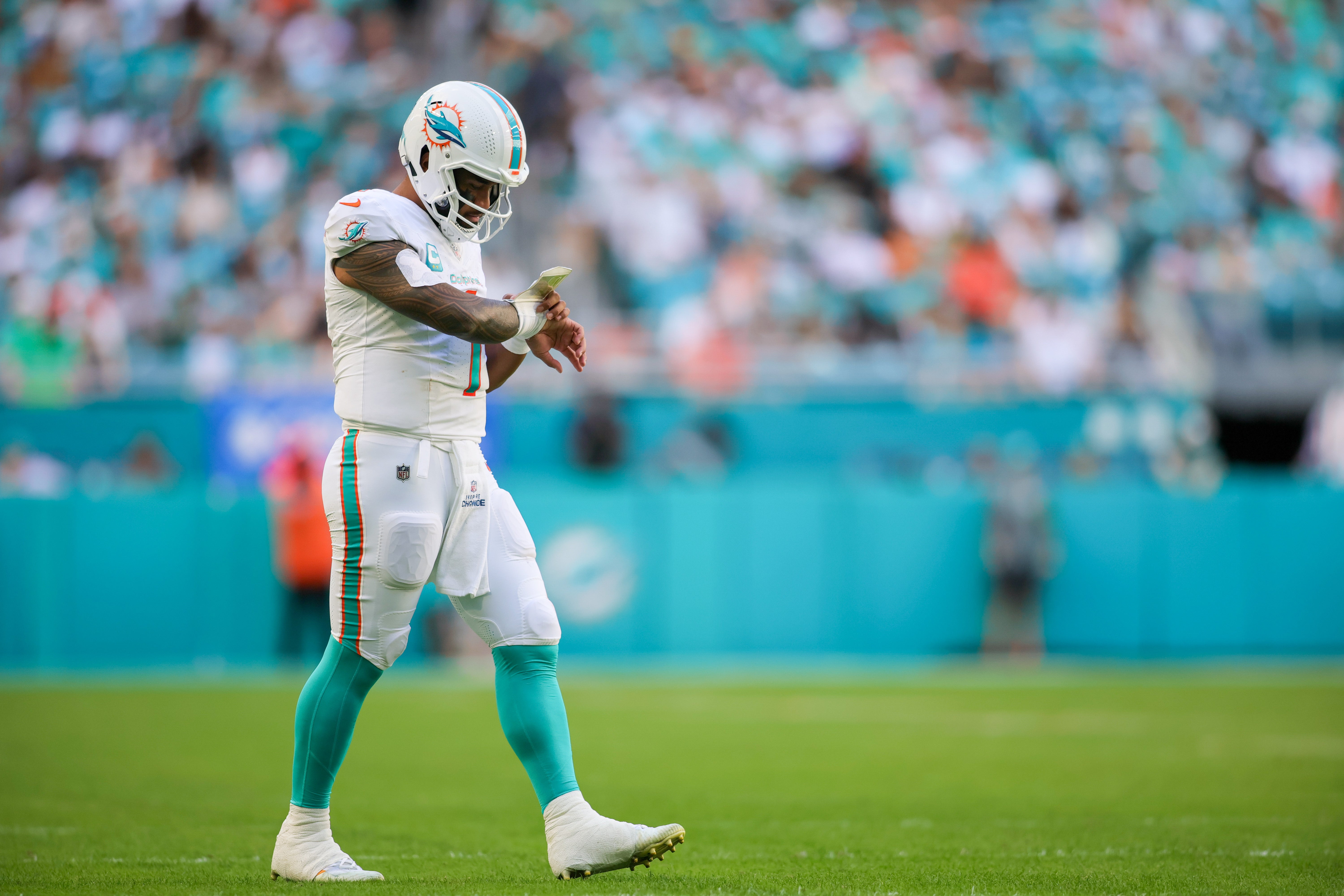 Dec 17, 2023; Miami Gardens, Florida, USA; Miami Dolphins quarterback Tua Tagovailoa (1) looks at his play sheet during the second quarter against the New York Jets at Hard Rock Stadium. Mandatory Credit: Sam Navarro-USA TODAY Sports