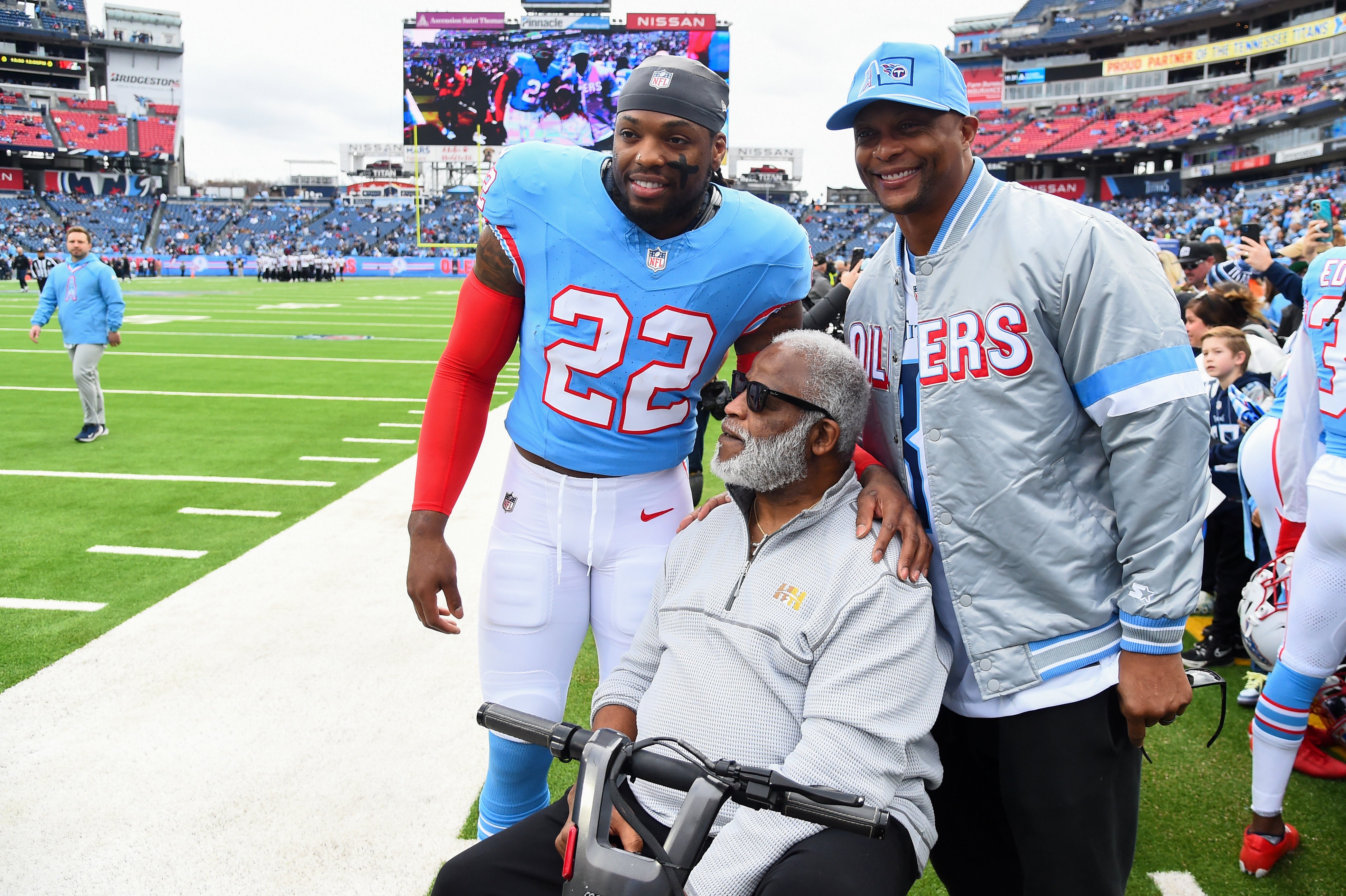 Dec 17, 2023; Nashville, Tennessee, USA; Tennessee Titans running back Derrick Henry (22) takes a picture with former running backs Eddie George and Earl Campbell as he leaves the field before the game against the Houston Texans at Nissan Stadium. Mandatory Credit: Christopher Hanewinckel-USA TODAY Sports