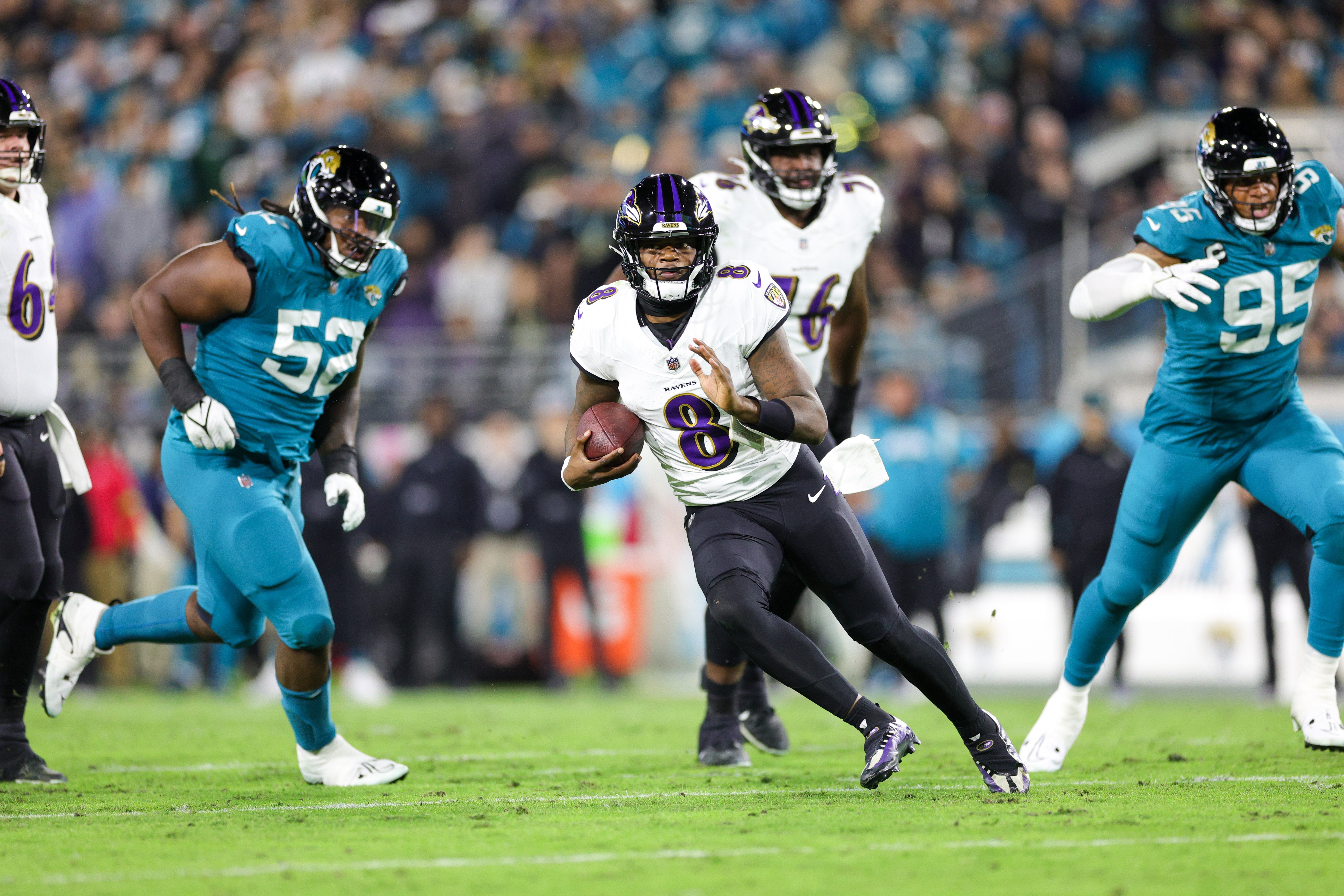 Baltimore Ravens quarterback Lamar Jackson (8) runs with the ball against the Jacksonville Jaguars in the first quarter at EverBank Stadium.