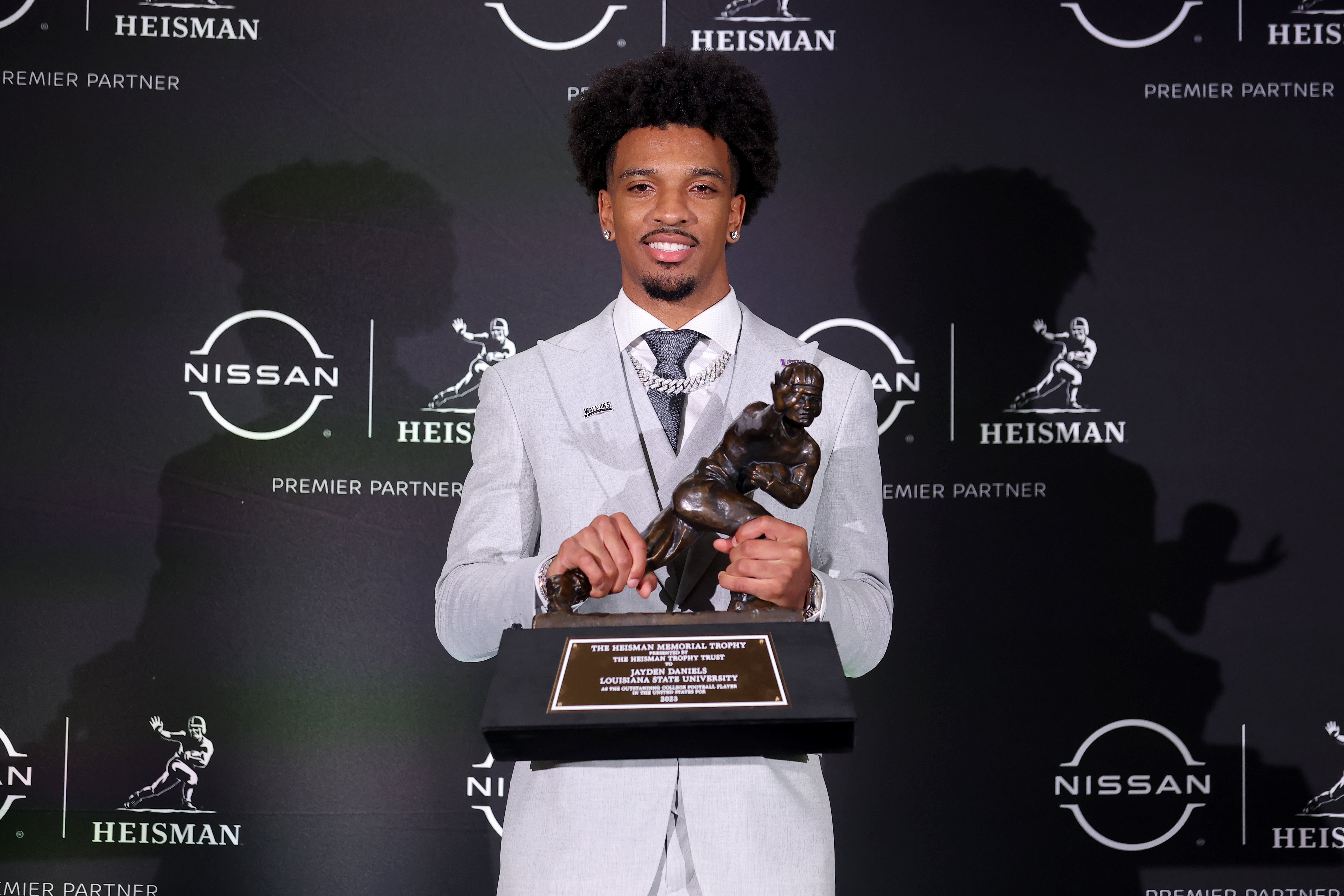 Dec 9, 2023; New York, New York, USA; LSU Tigers quarterback Jayden Daniels poses for photos with the Heisman trophy during a press conference in the Astor ballroom at the New York Marriott Marquis after winning the Heisman trophy.