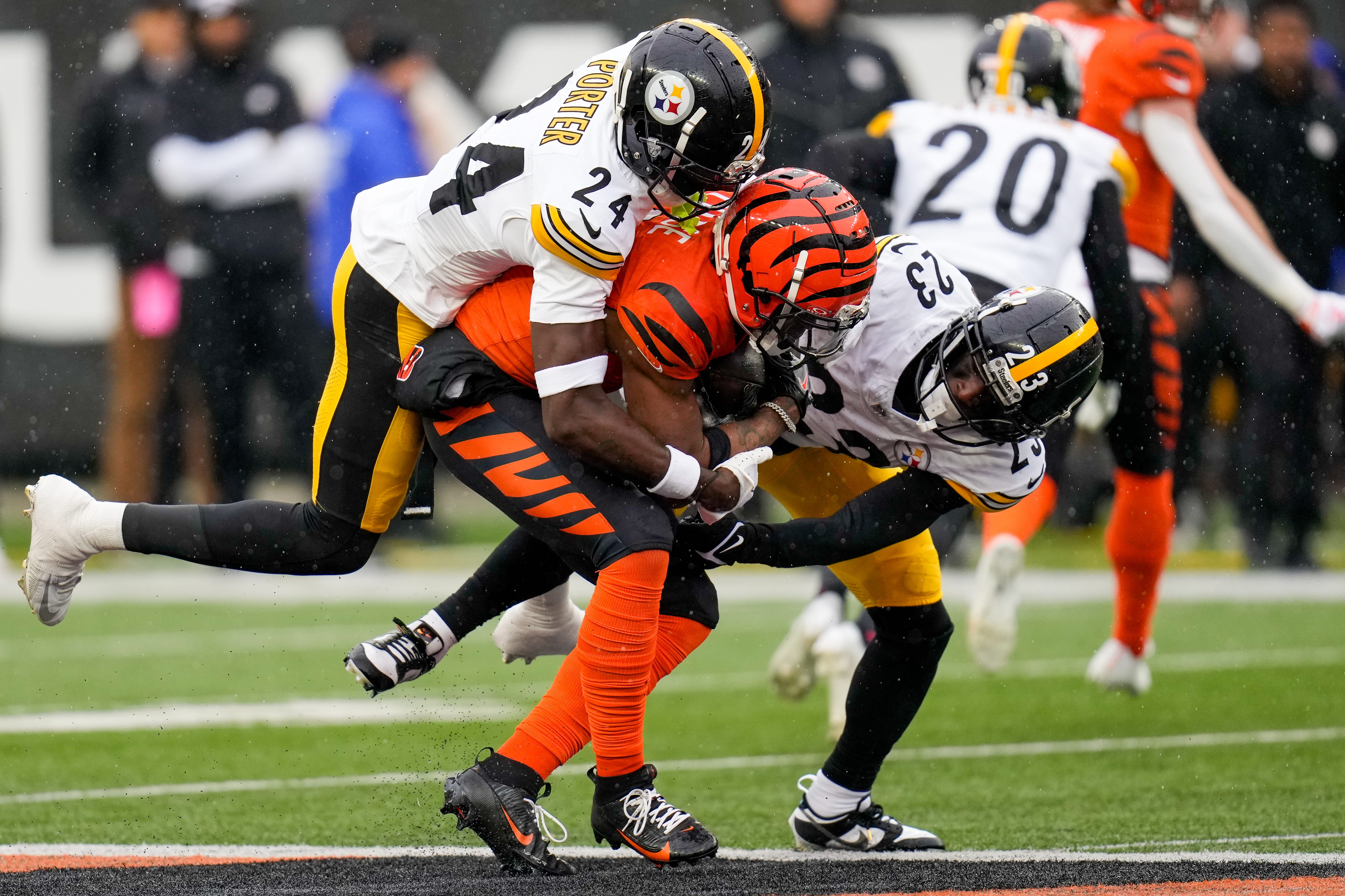 Cincinnati Bengals wide receiver Ja'Marr Chase (1) is pulled down by Pittsburgh Steelers cornerback Joey Porter Jr. (24) and safety Damontae Kazee (23) in the first quarter of the NFL Week 12 game between the Cincinnati Bengals and the Pittsburgh Steelers at Paycor Stadium in Cincinnati on Sunday, Nov. 26, 2023.  