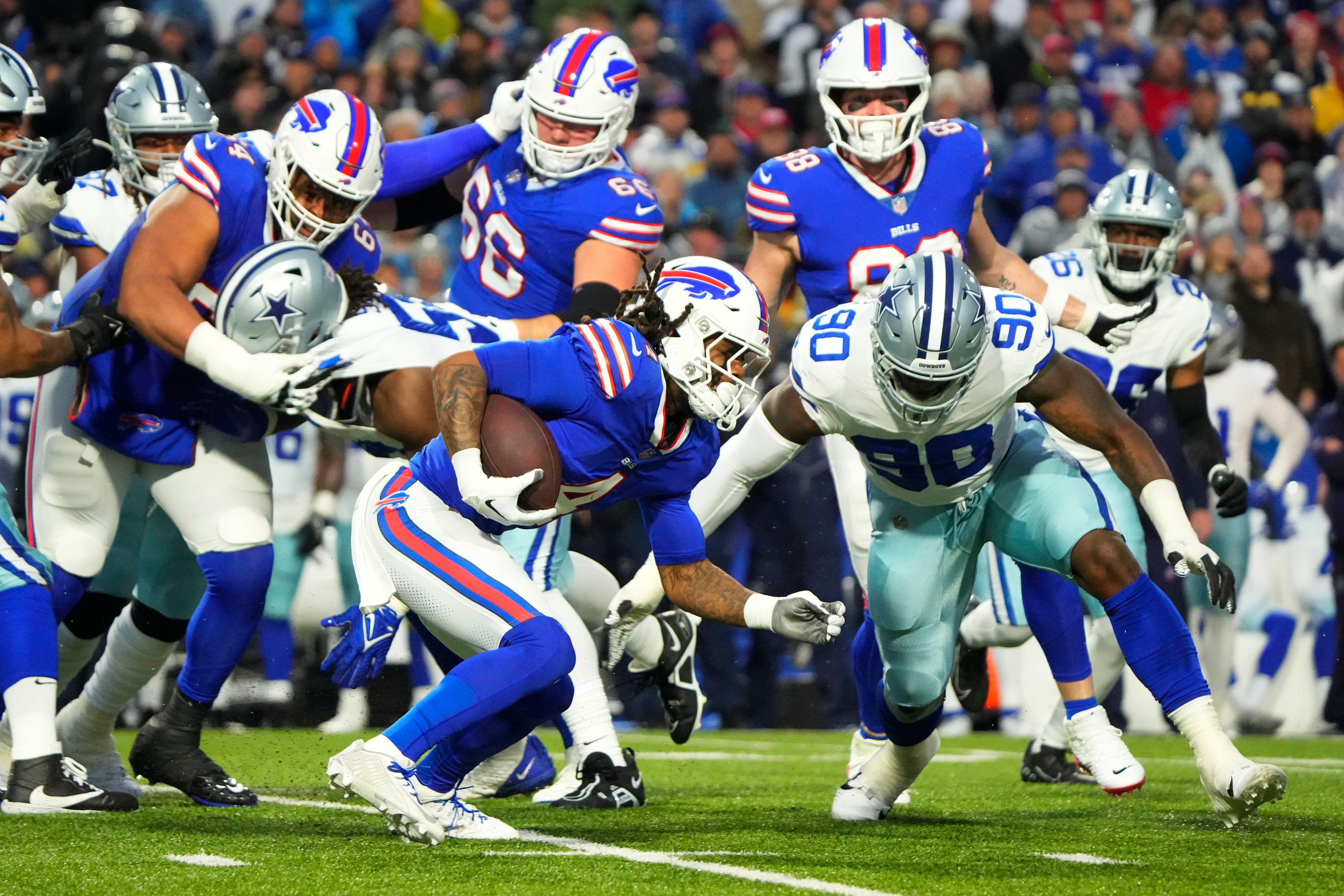 Buffalo Bills running back James Cook is tackled by Dallas Cowboys defensive end DeMarcus Lawrence (90) in the first half at Highmark Stadium.