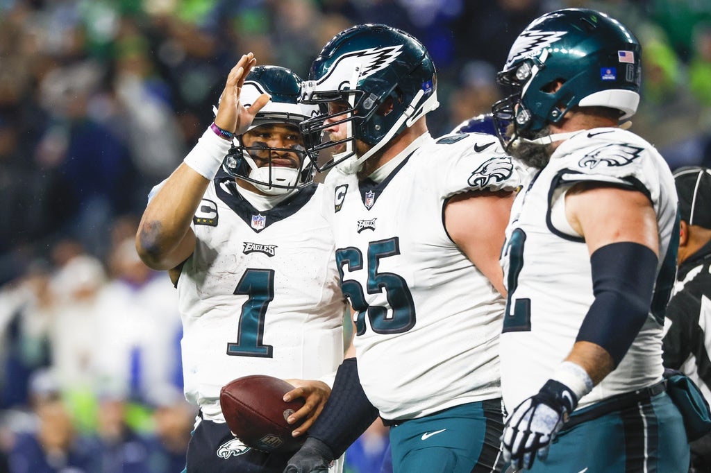 Philadelphia Eagles quarterback Jalen Hurts (1) pats offensive tackle Lane Johnson (65) on the head after rushing for a touchdown against the Seattle Seahawks during the third quarter at Lumen Field.