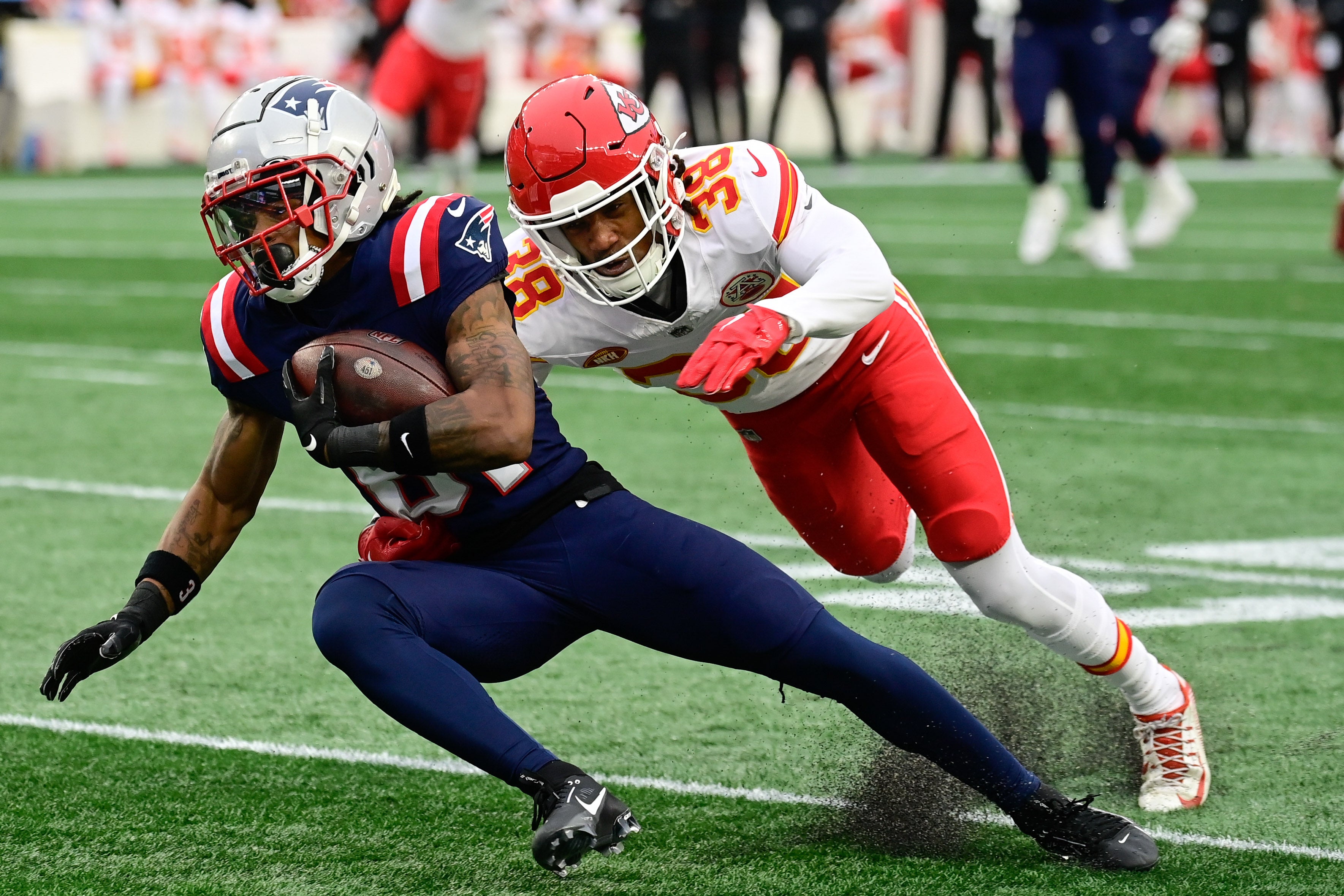 Kansas City Chiefs cornerback L'Jarius Sneed tackles New England Patriots wide receiver Demario Douglas during the first half at Gillette Stadium