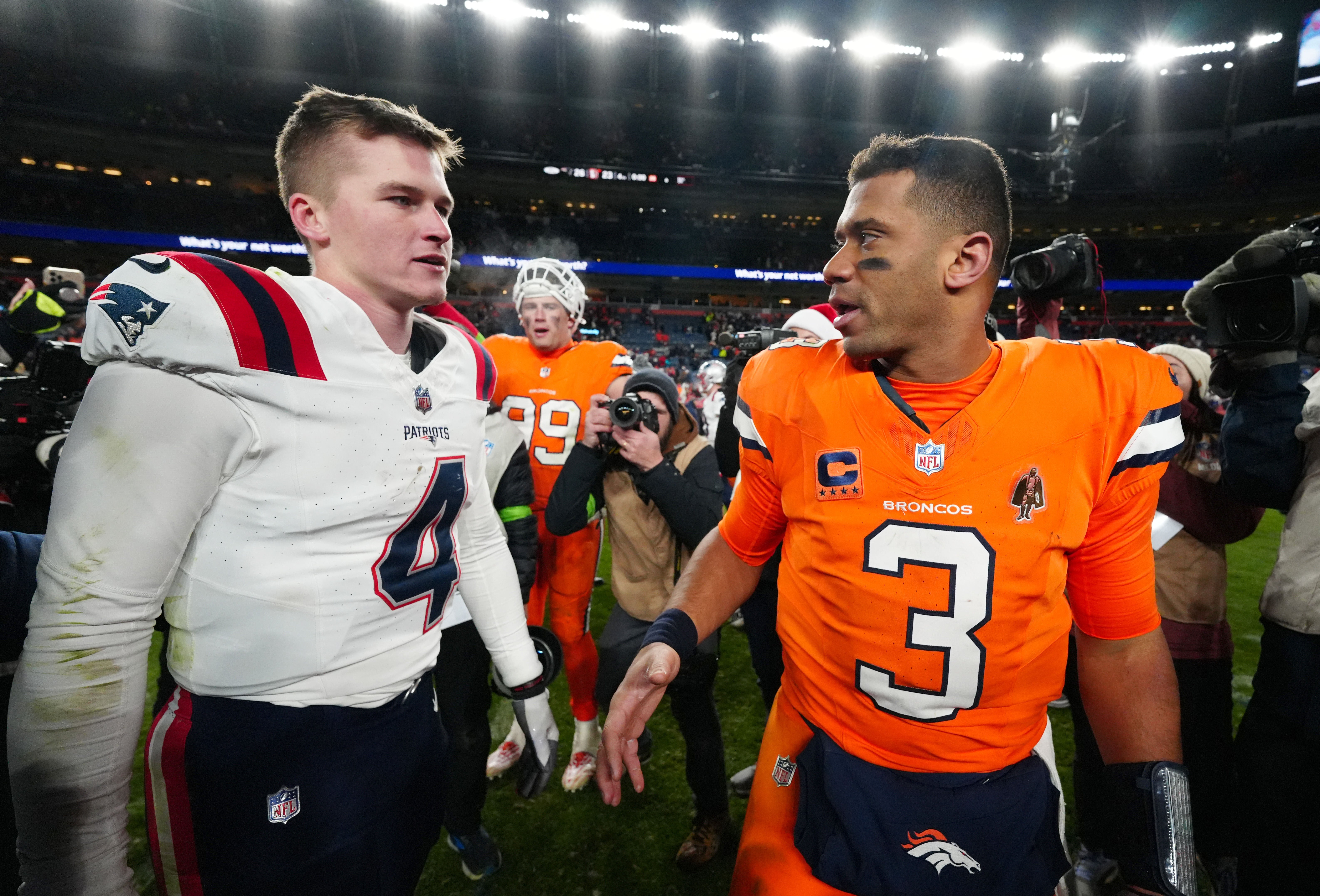 New England Patriots quarterback Bailey Zappe and Denver Broncos quarterback Russell Wilson following the game at Empower Field at Mile High