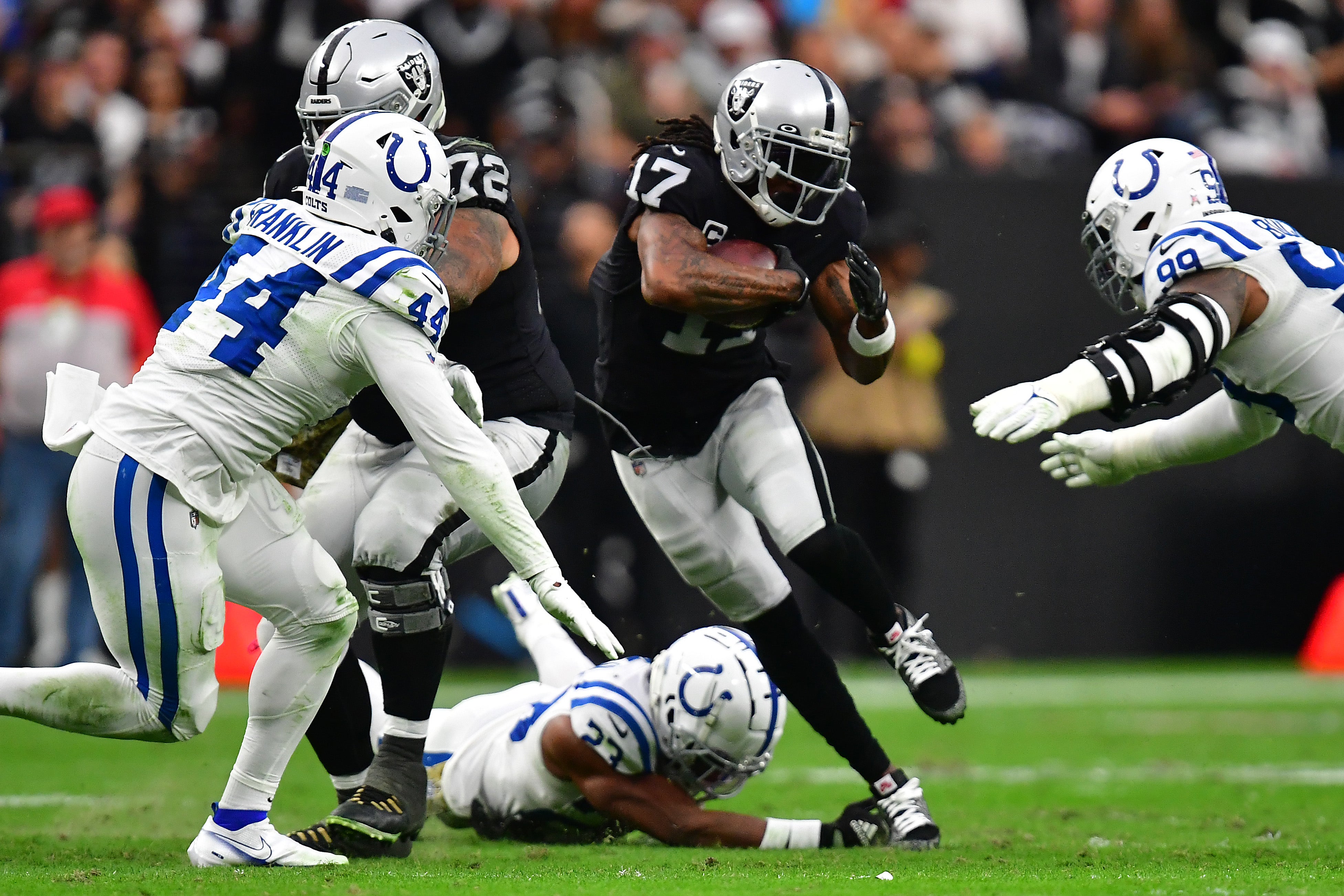 Nov 13, 2022; Paradise, Nevada, USA; Las Vegas Raiders wide receiver Davante Adams (17) runs the ball against Indianapolis Colts cornerback Kenny Moore II (23) defensive tackle DeForest Buckner (99) and linebacker Zaire Franklin (44) during the first half at Allegiant Stadium.