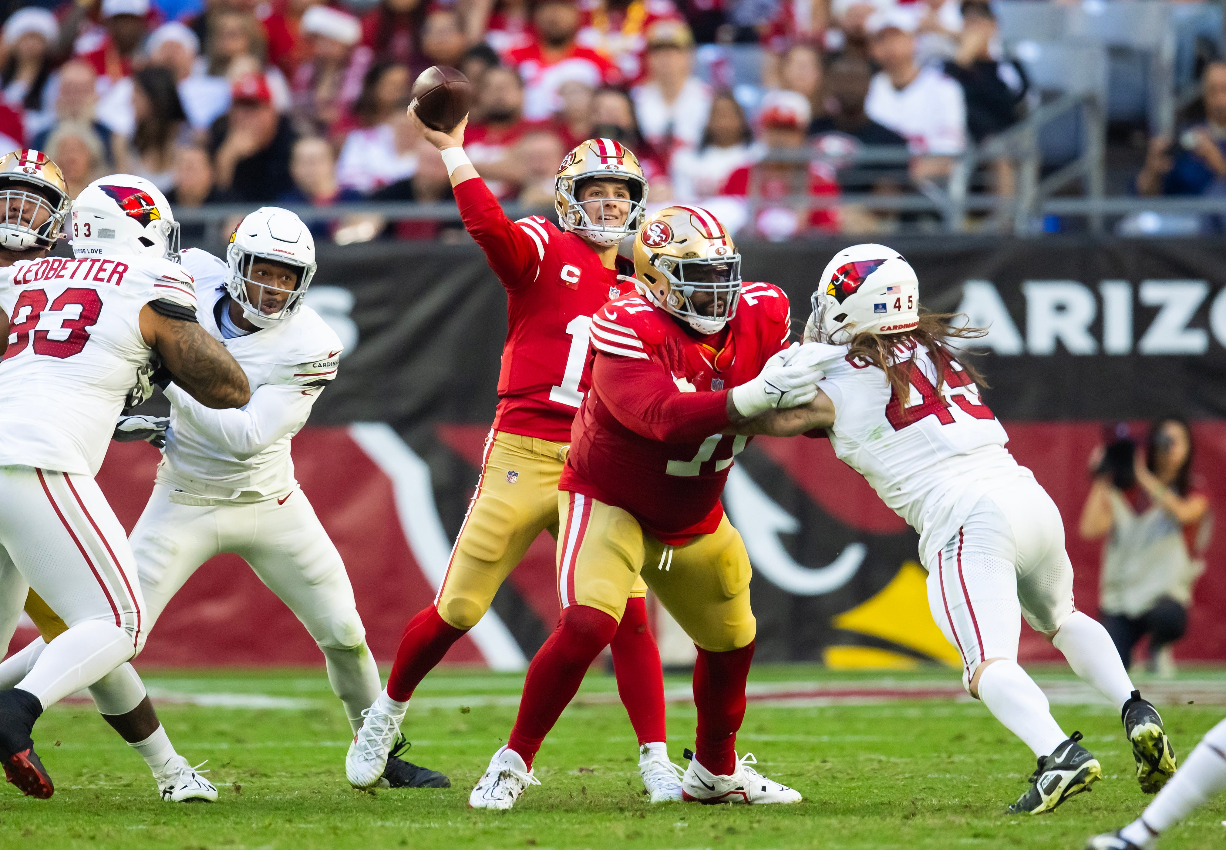 Dec 17, 2023; Glendale, Arizona, USA; San Francisco 49ers offensive lineman Trent Williams (71) blocks for quarterback Brock Purdy (13) against Arizona Cardinals linebacker Dennis Gardeck (45) at State Farm Stadium.