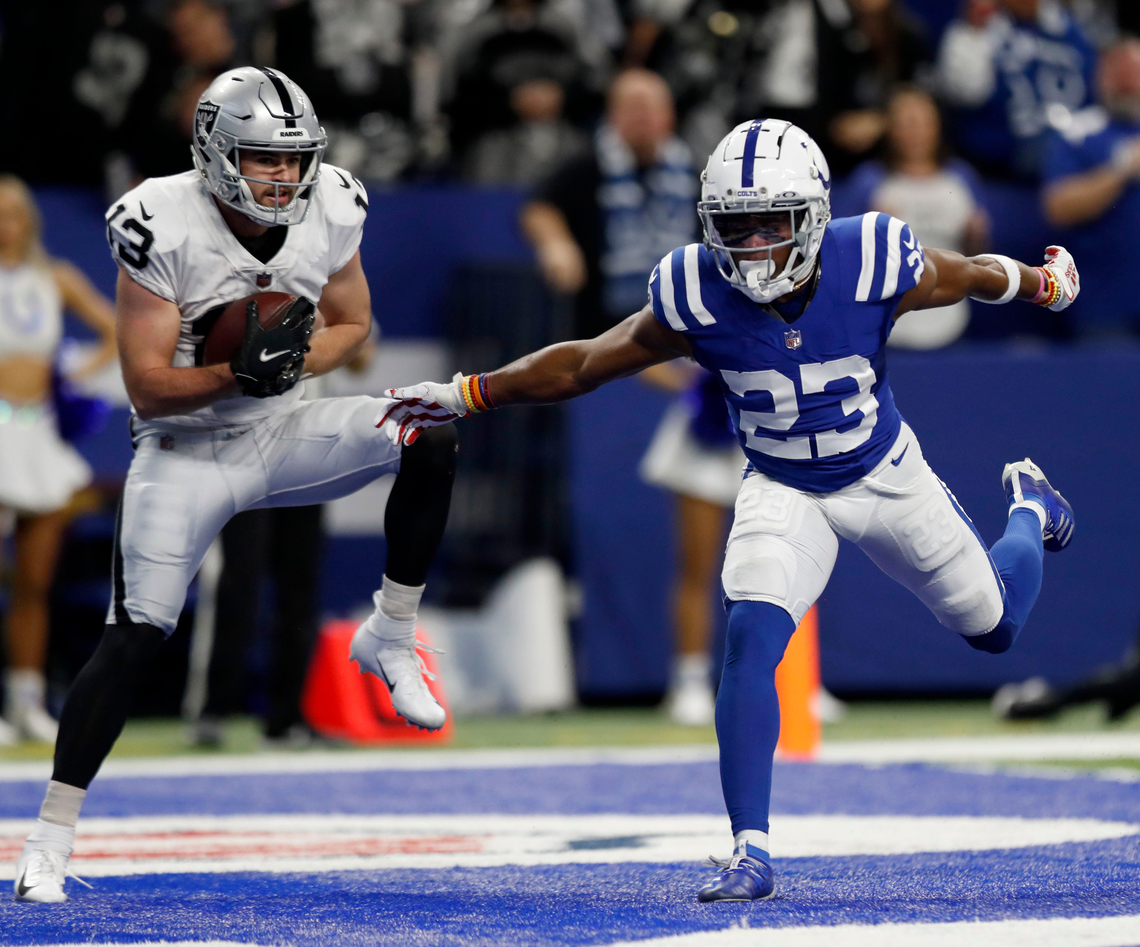 Las Vegas Raiders wide receiver Hunter Renfrow (13) makes a touchdown catch under the pressure of Indianapolis Colts cornerback Kenny Moore II (23) on Sunday, Jan. 2, 2022, during a game at Lucas Oil Stadium in Indianapolis.
