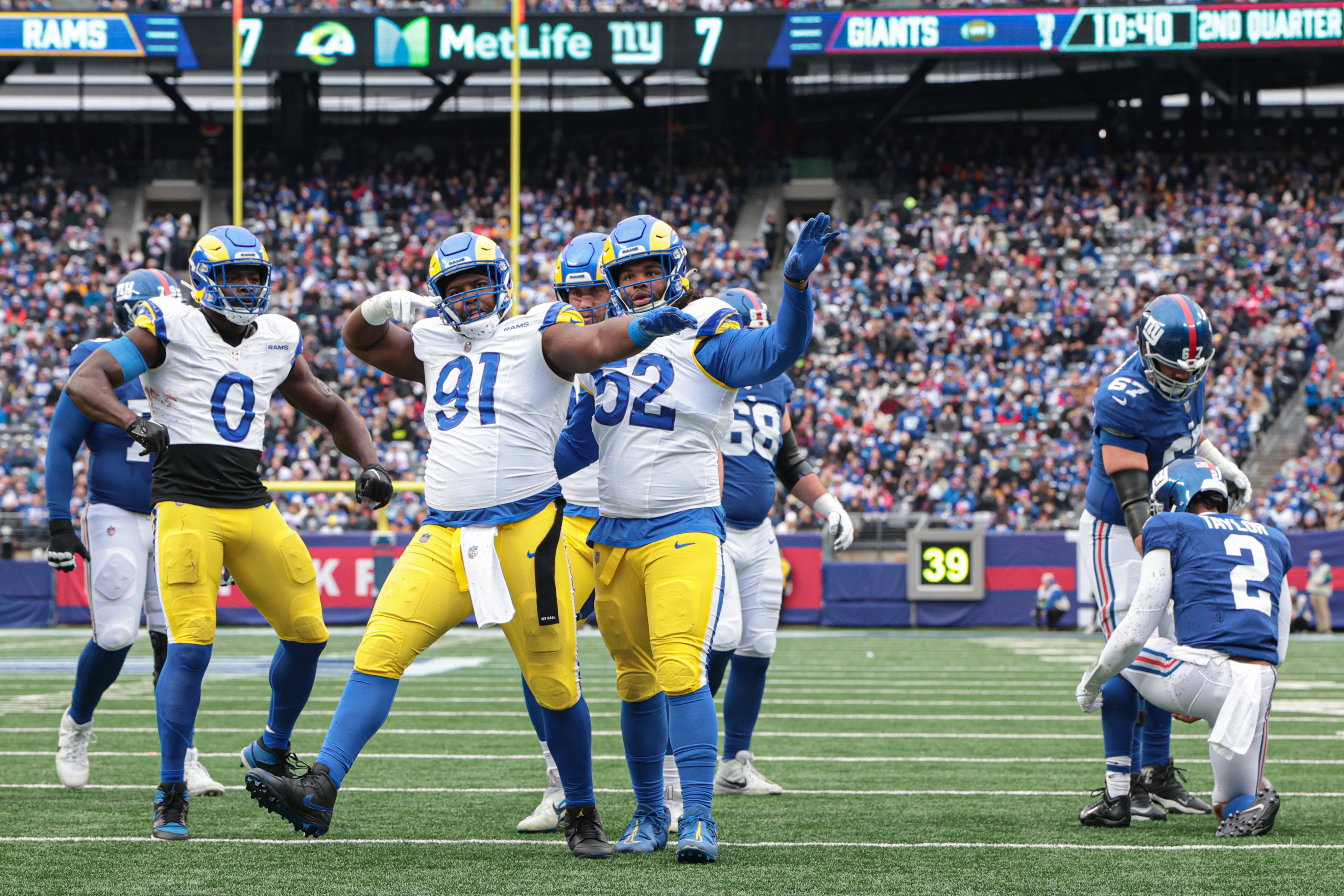 Dec 31, 2023; East Rutherford, New Jersey, USA; Los Angeles Rams defensive tackle Kobie Turner (91) and defensive tackle Larrell Murchison (52) and linebacker Byron Young (0) celebrates after a sack on New York Giants quarterback Tyrod Taylor (2) during the first half at MetLife Stadium. Mandatory Credit: Vincent Carchietta-USA TODAY Sports