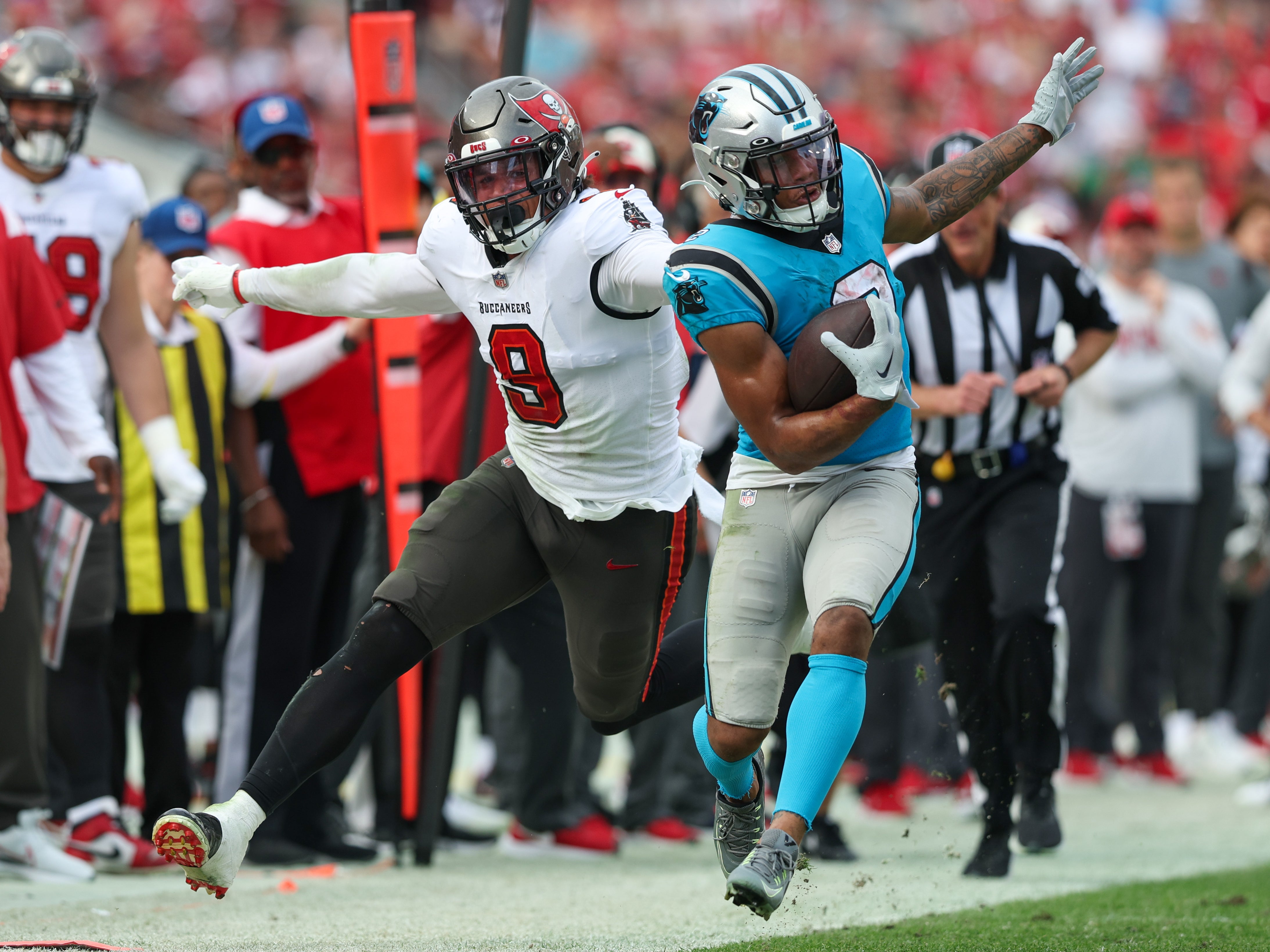 Jan 1, 2023; Tampa, Florida, USA; Tampa Bay Buccaneers linebacker Joe Tryon-Shoyinka (9) grabs the collar of Carolina Panthers wide receiver DJ Moore (2) in the third quarter at Raymond James Stadium. Mandatory Credit: Nathan Ray Seebeck-USA TODAY Sports
