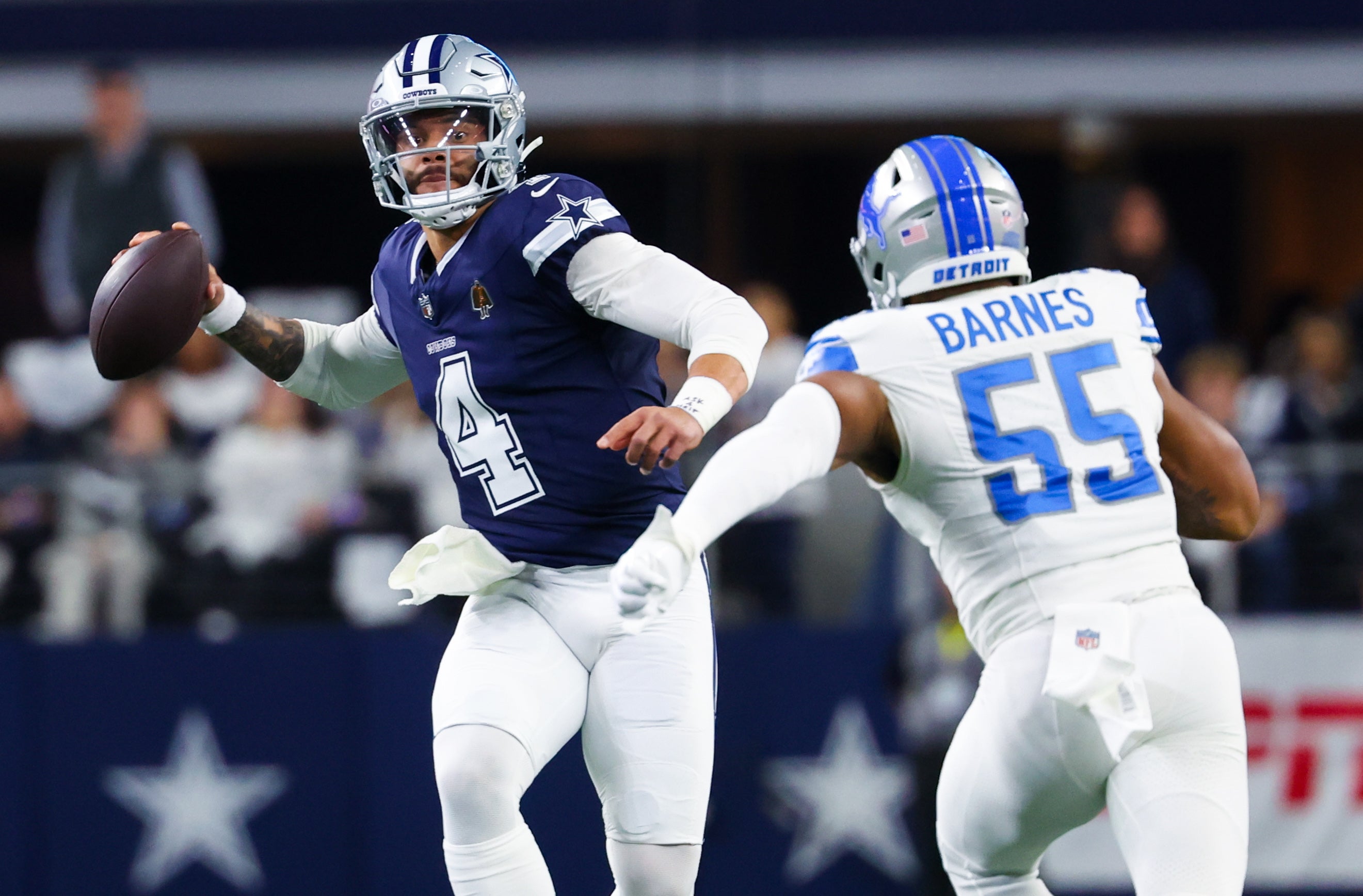 Dallas Cowboys quarterback Dak Prescott (4) looks to throw as Detroit Lions linebacker Derrick Barnes (55) defends during the first half at AT&T Stadium.
