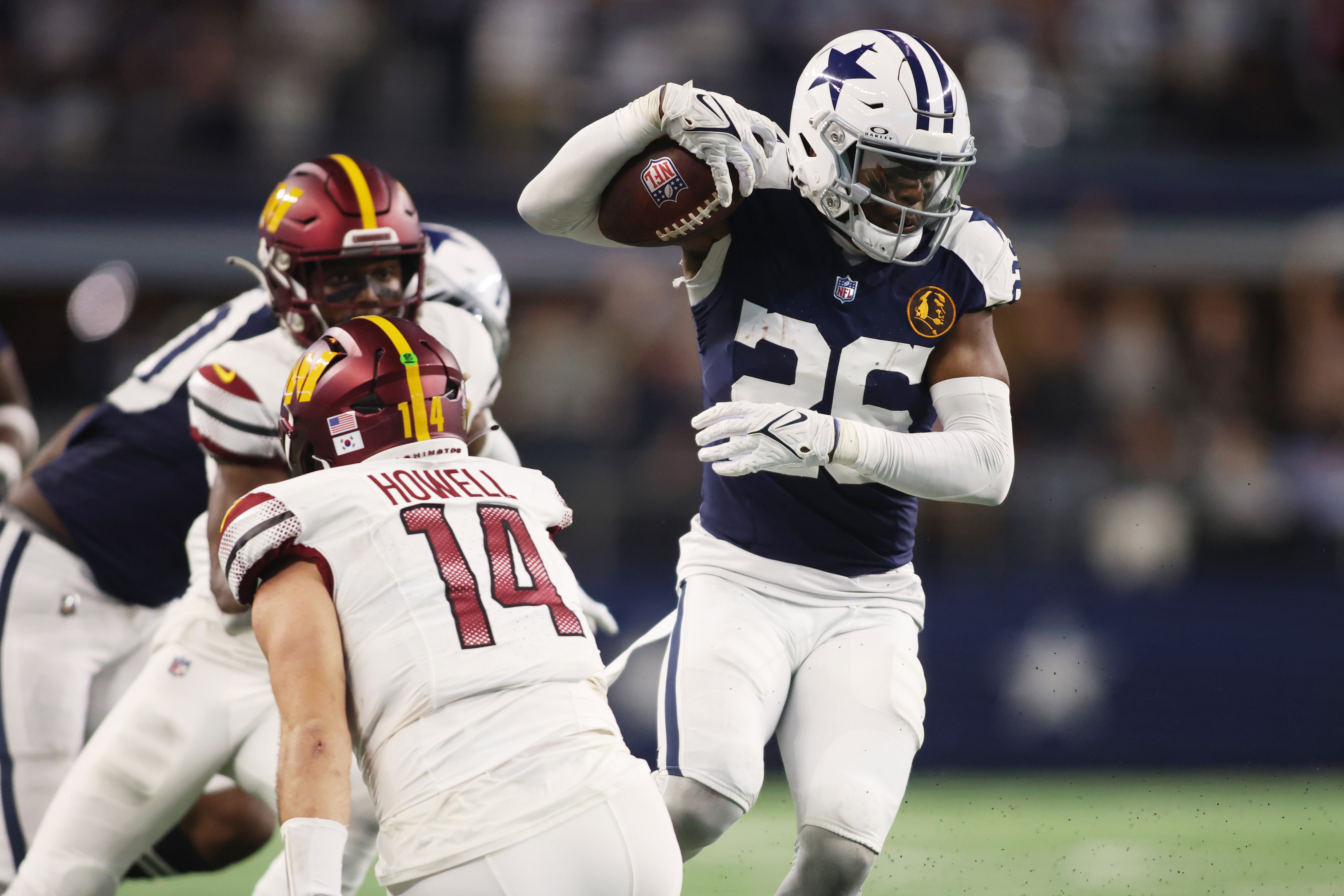 Dallas Cowboys cornerback DaRon Bland (26) returns an interception for a touchdown in the fourth quarter against Washington Commanders quarterback Sam Howell (14) at AT&T Stadium.