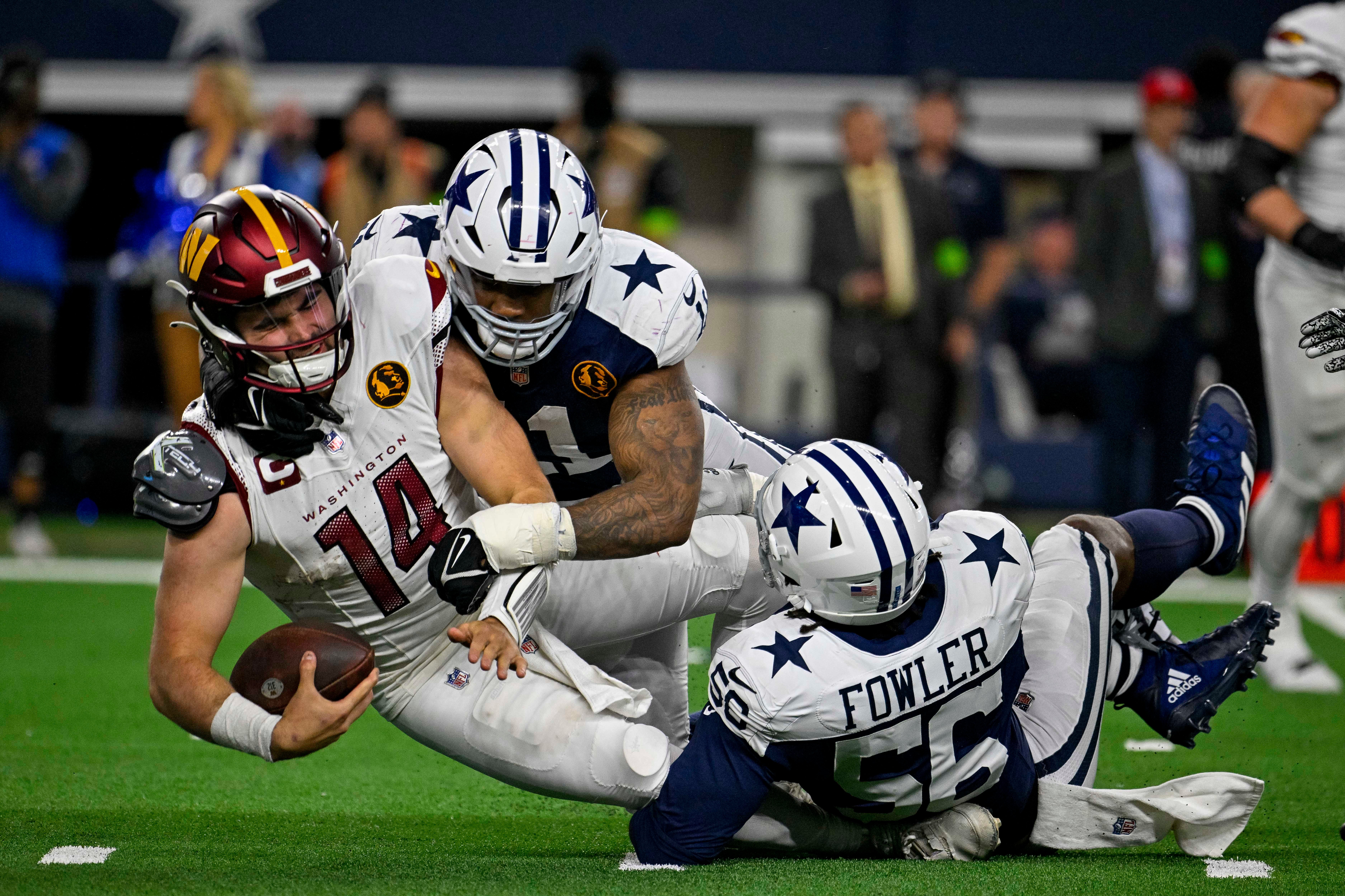 Dallas Cowboys linebacker Micah Parsons (11) and defensive end Dante Fowler Jr. (56) and Washington Commanders quarterback Sam Howell (14) in action during the game between the Dallas Cowboys and the Washington Commanders at AT&T Stadium.