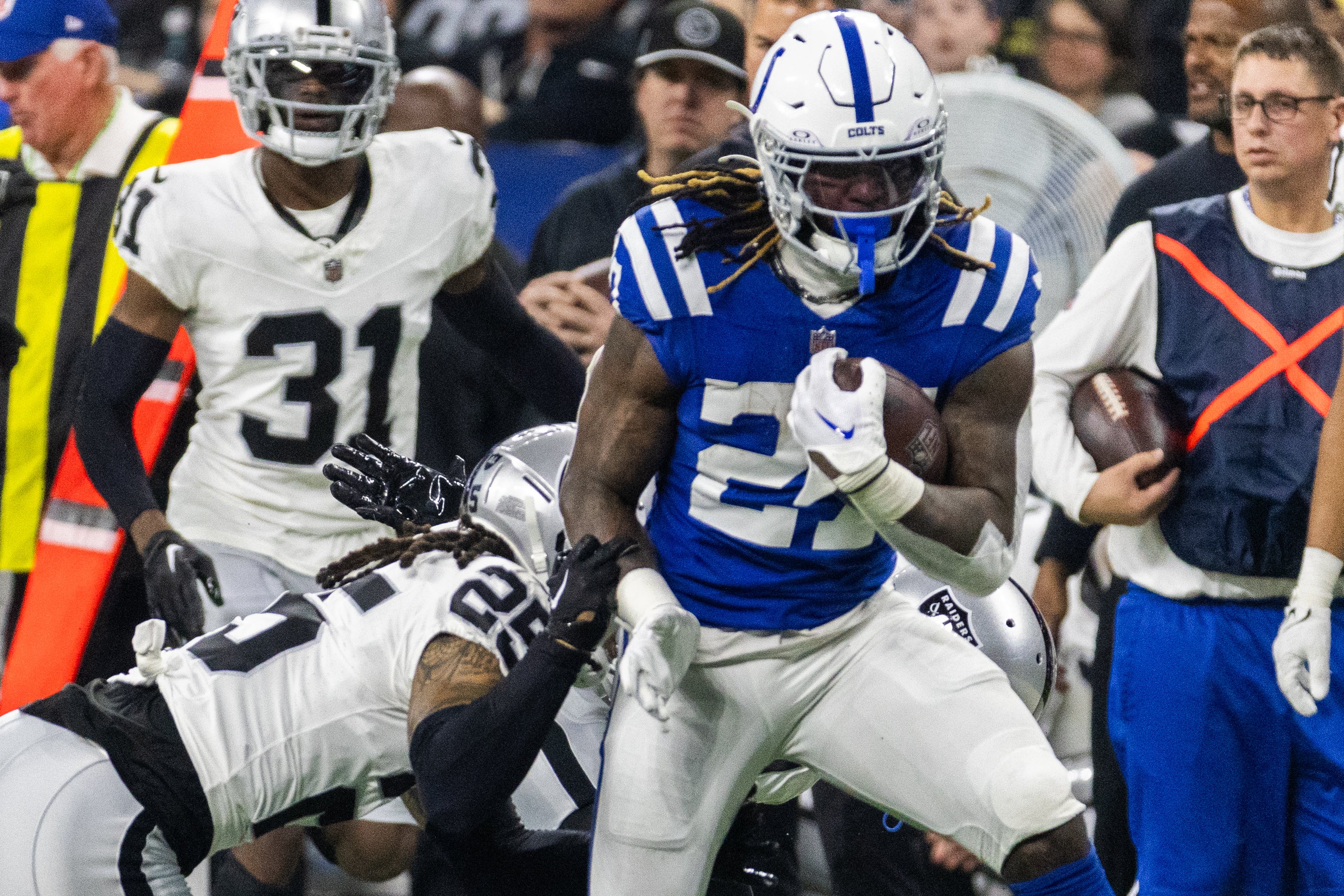 Dec 31, 2023; Indianapolis, Indiana, USA; Indianapolis Colts running back Trey Sermon (27) runs the ball while Las Vegas Raiders safety Marcus Epps (1) and safety Tre'von Moehrig (25) defend in the second half at Lucas Oil Stadium.