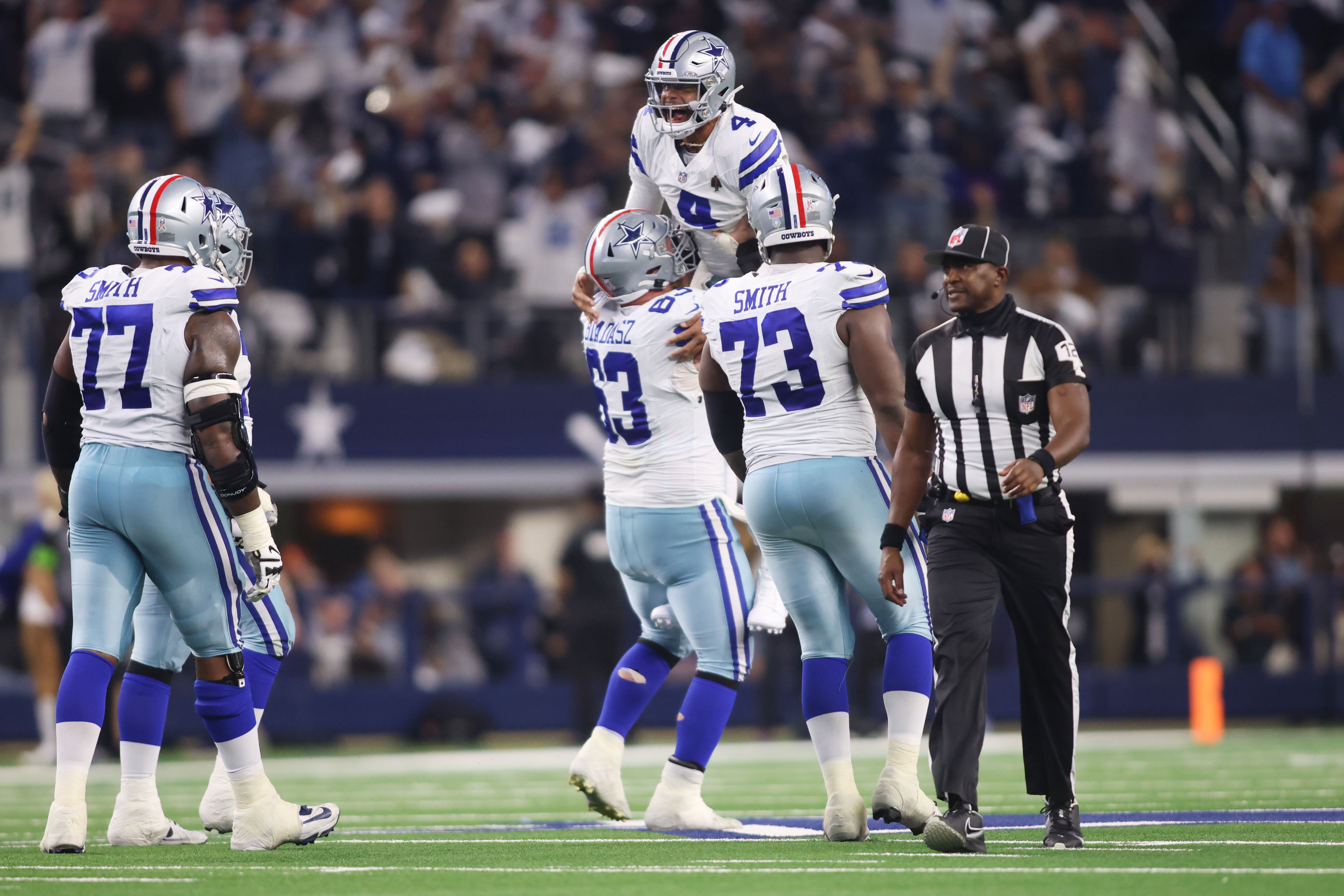 Dallas Cowboys quarterback Dak Prescott (4) celebrates a touchdown against the New York Giants with center Tyler Biadasz (63) and offensive tackle Tyler Smith (73) in the third quarter at AT&T Stadium.