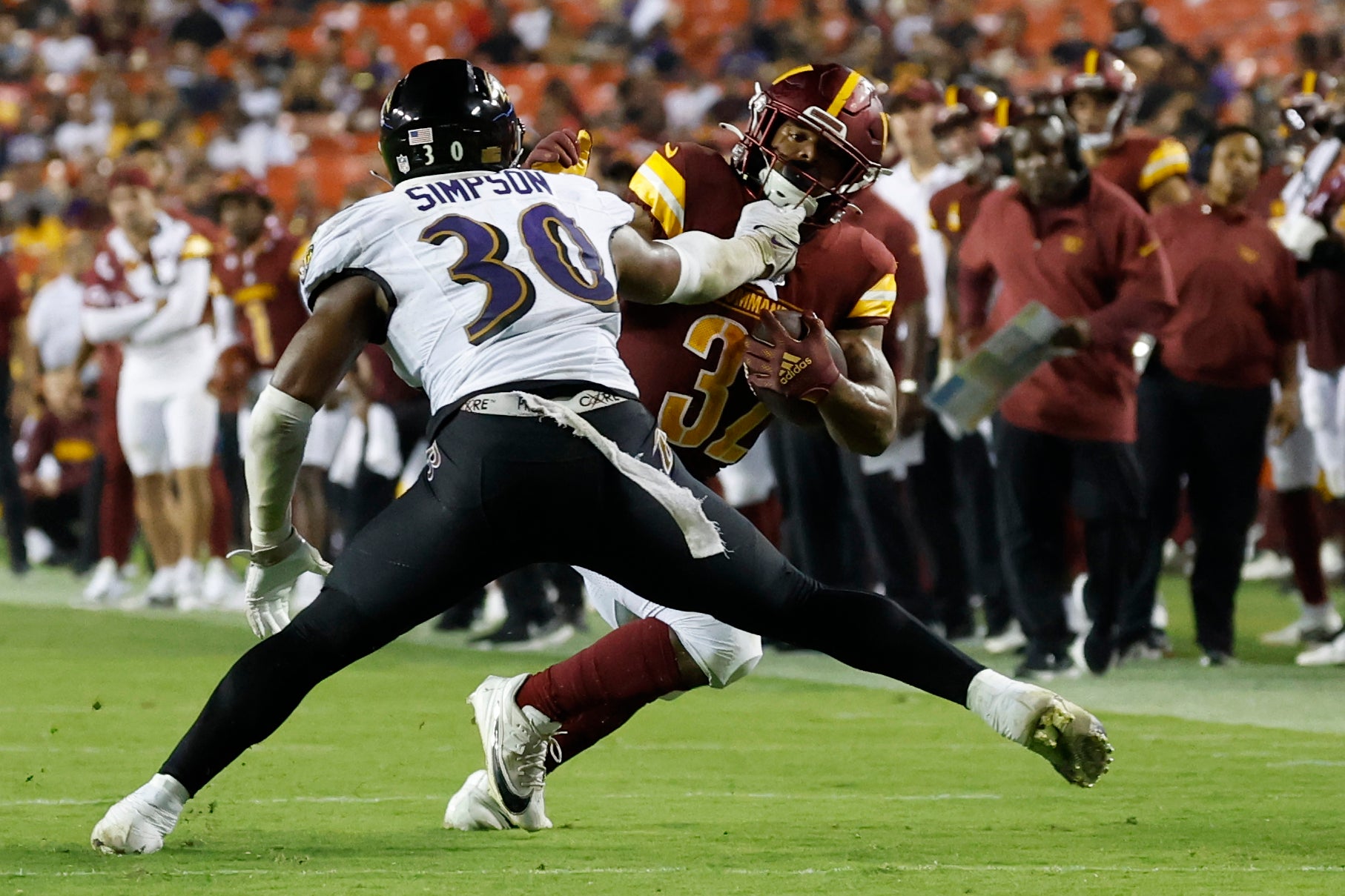 Washington Commanders running back Jaret Patterson (32) carries the ball past Baltimore Ravens linebacker Trenton Simpson (30) en route to a touchdown during the fourth quarter at FedExField.