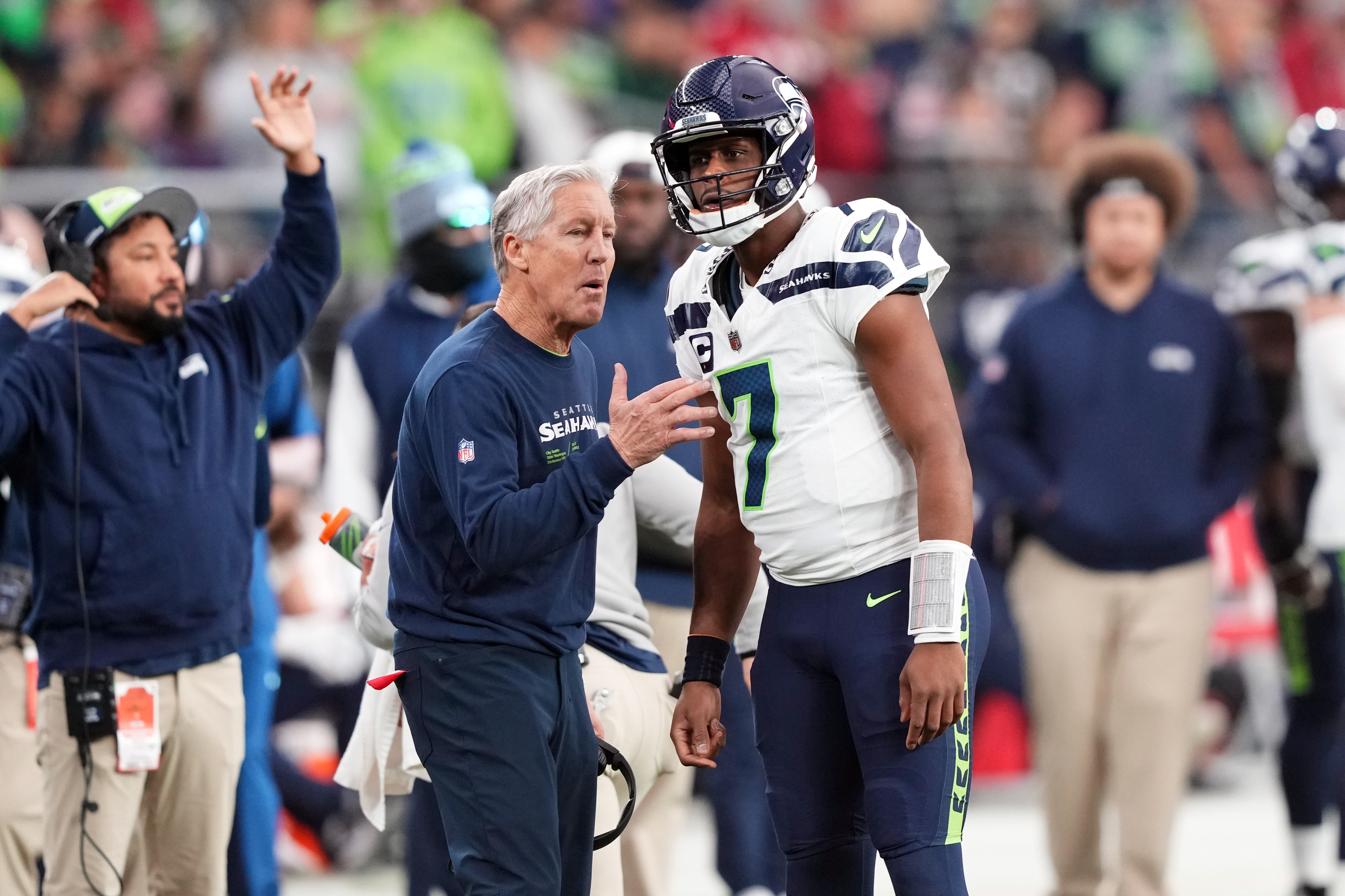 Jan 7, 2024; Glendale, Arizona, USA; Seattle Seahawks head coach Pete Carroll talks with Seattle Seahawks quarterback Geno Smith (7) against the Arizona Cardinals during the first half at State Farm Stadium.