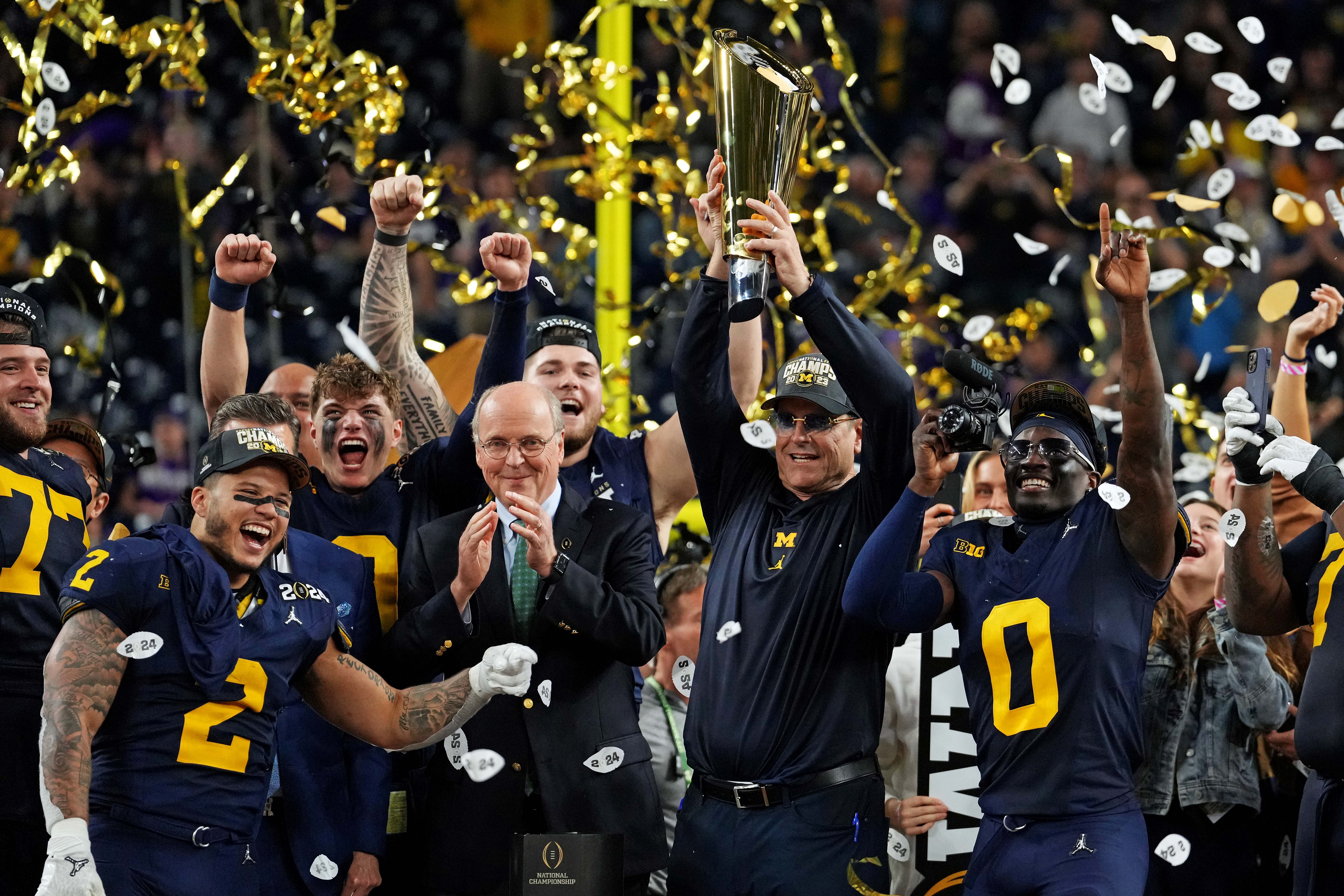 Jan 8, 2024; Houston, TX, USA; Michigan Wolverines head coach Jim Harbaugh celebrates with the CFP Championship trophy after beating the Washington Huskies in the 2024 College Football Playoff national championship game at NRG Stadium.