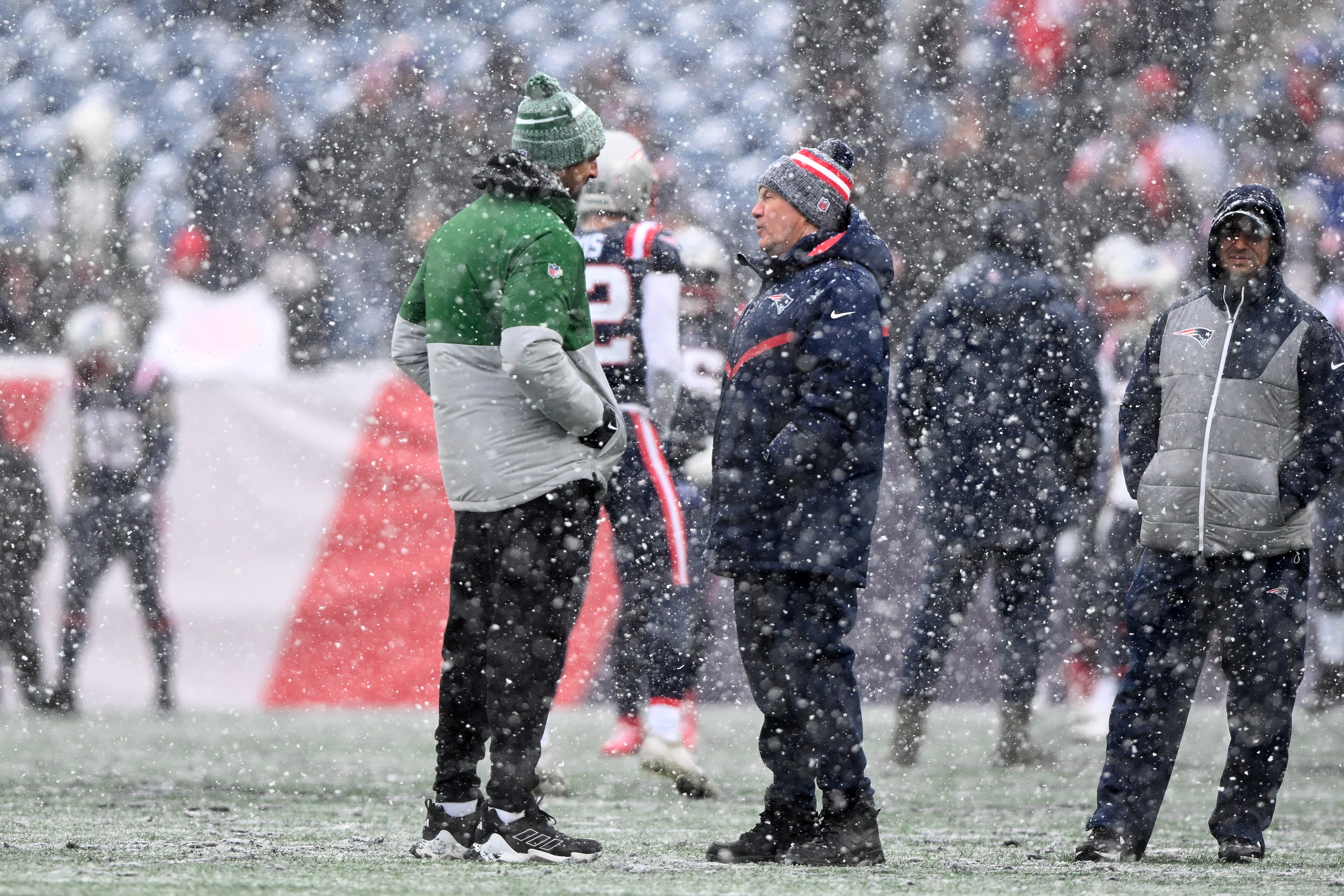 New York Jets quarterback Aaron Rodgers  talks with New England Patriots head coach Bill Belichick before a game at Gillette Stadium.