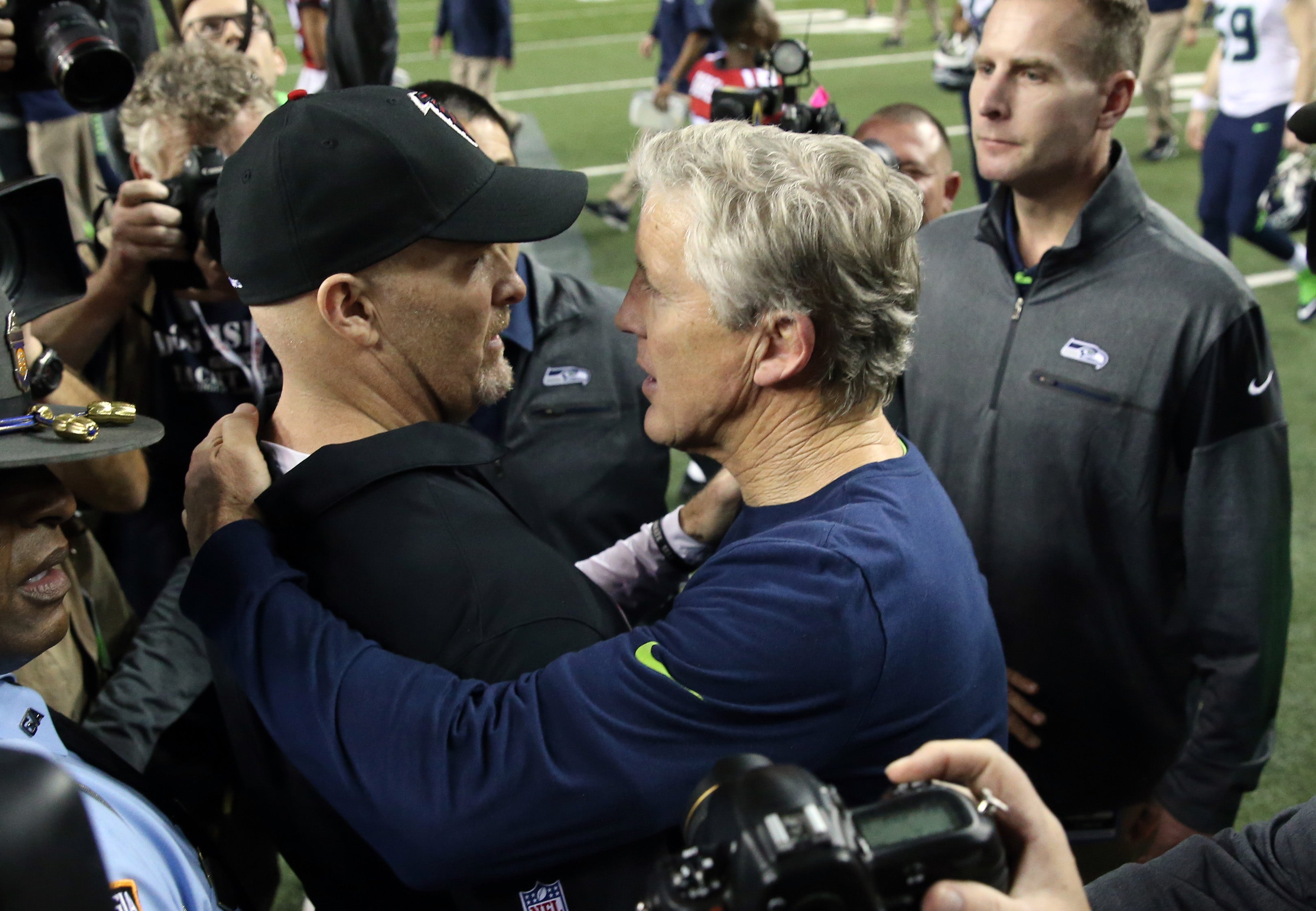 Atlanta Falcons head coach Dan Quinn (left) and Seattle Seahawks head coach Pete Carroll embrace after the NFC Divisional playoff at Georgia Dome. Atlanta won 36-20.