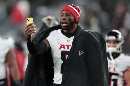 Atlanta Falcons tight end Kyle Pitts (8) addresses social media on a smart phone while walking off the field after the game against the New York Jets at MetLife Stadium.