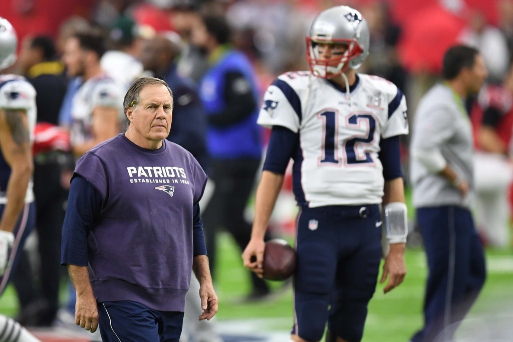 New England Patriots head coach Bill Belichick walks the field during warm-ups as quarterback Tom Brady (12) stands in the background before Super Bowl LI against the Atlanta Falcons at NRG Stadium.