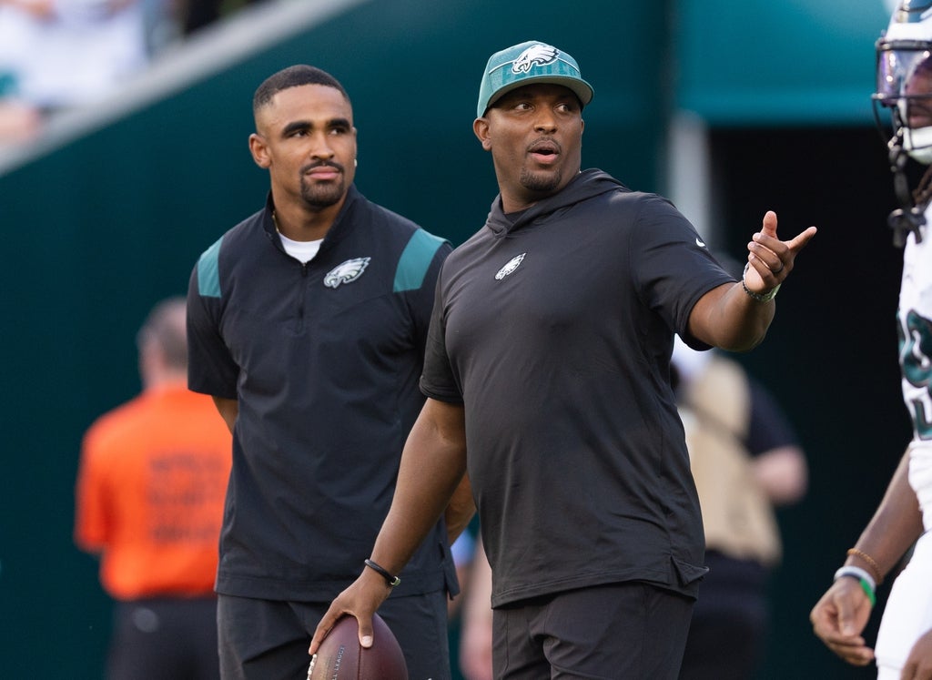 Philadelphia Eagles offensive coordinator Brian Johnson talks with Jalen Hurts before a game against the Cleveland Browns at Lincoln Financial Field.