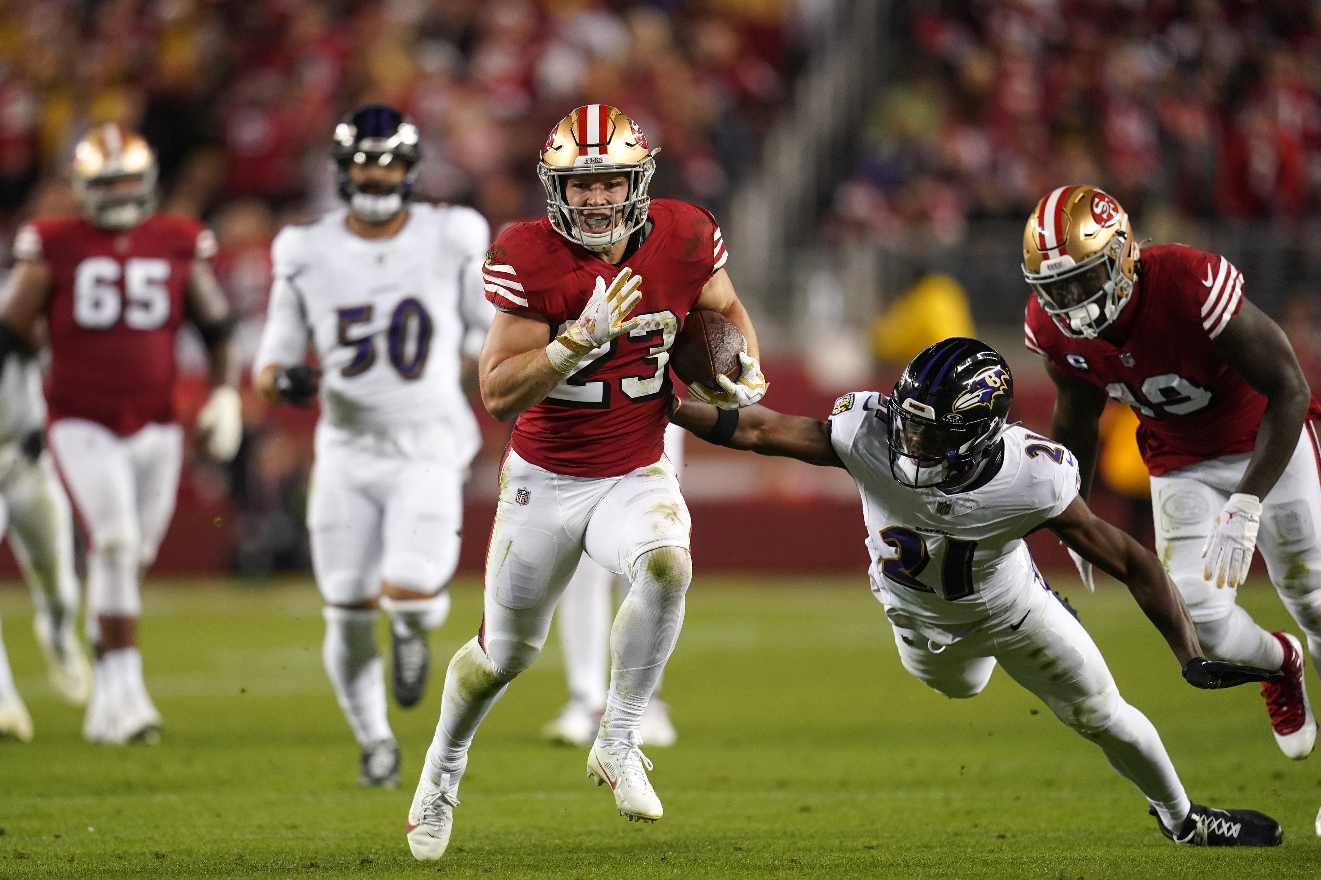 Dec 25, 2023; Santa Clara, California, USA; San Francisco 49ers running back Christian McCaffrey (23) runs the ball pressured by Baltimore Ravens cornerback Brandon Stephens (21) in the second quarter at Levi's Stadium.