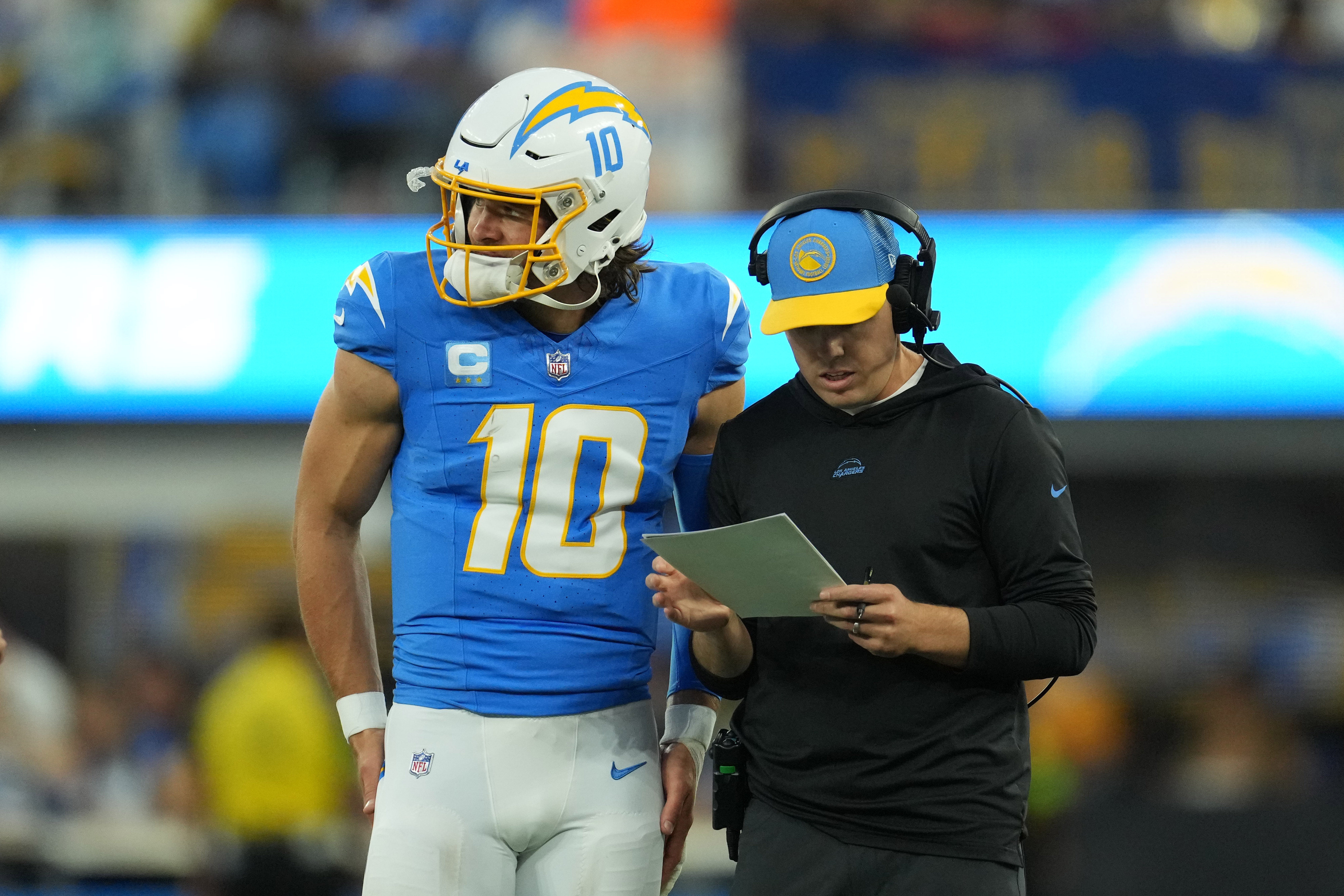 Los Angeles Chargers offensive coordinator Kellen Moore (right) talks with quarterback Justin Herbert (10) against the Chicago Bears in the first half at SoFi Stadium.