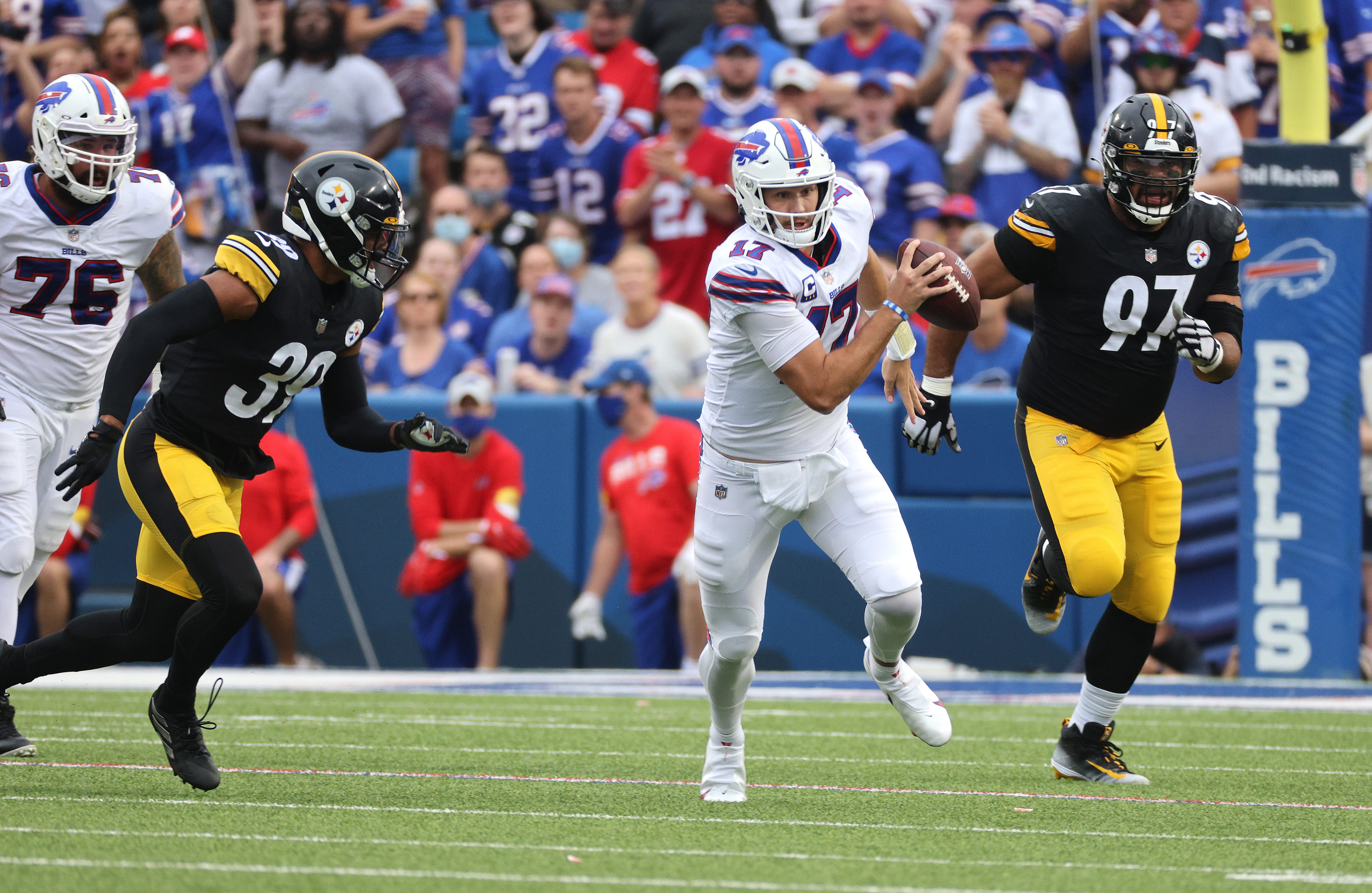 Bills quarterback Josh Allen pulls down the ball and runs against Steelers Minkah Fitzpatrick (39) and Cameron Heyward. Jg 091221 Bills 21