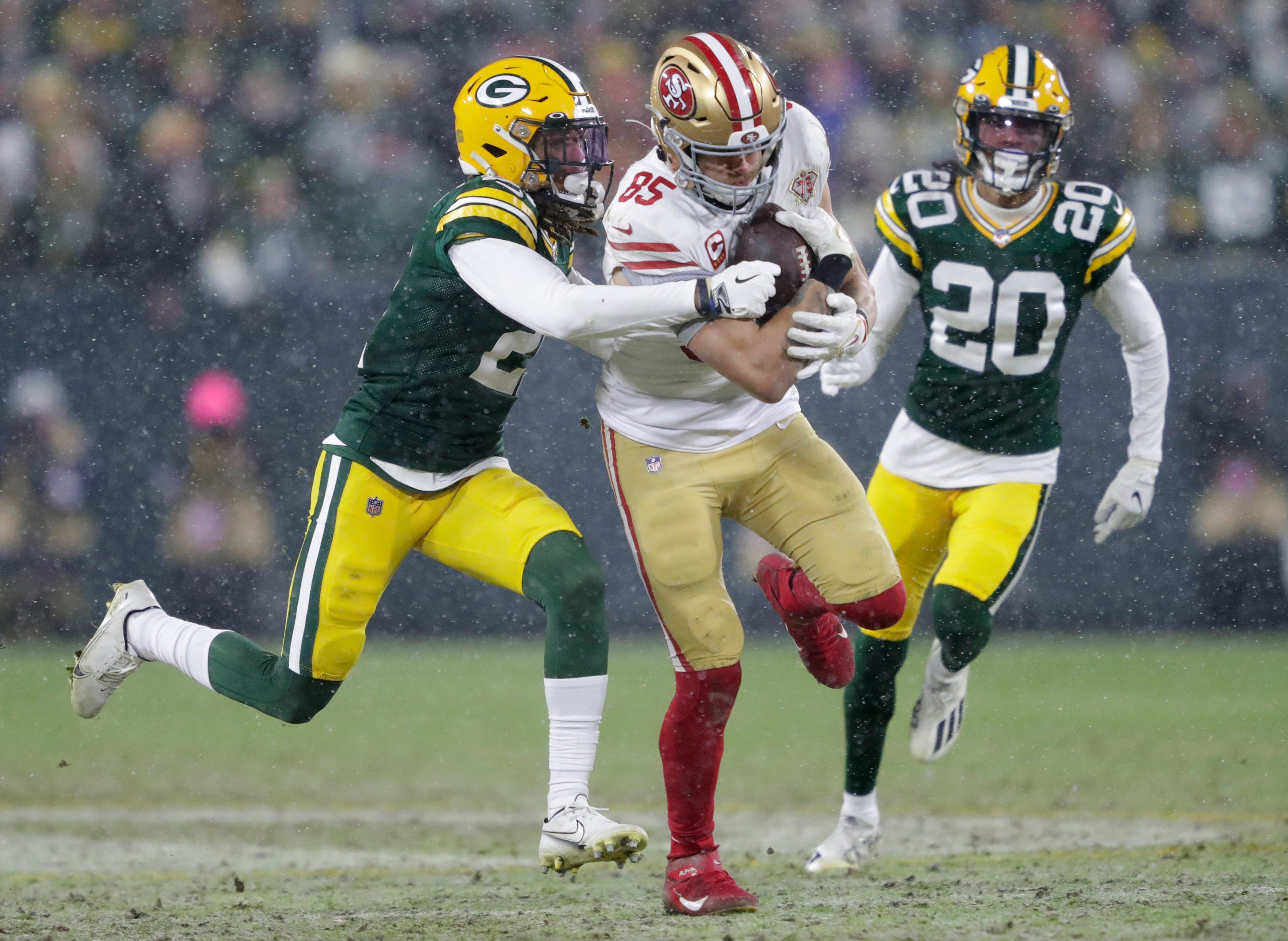 San Francisco 49ers tight end George Kittle (85) gets a long first down reception against Green Bay Packers cornerback Eric Stokes (21) and cornerback Kevin King (20) in the third quarter during their NFL divisional round football playoff game Saturday, Jan. 22, 2022, at Lambeau Field in Green Bay, Wis.