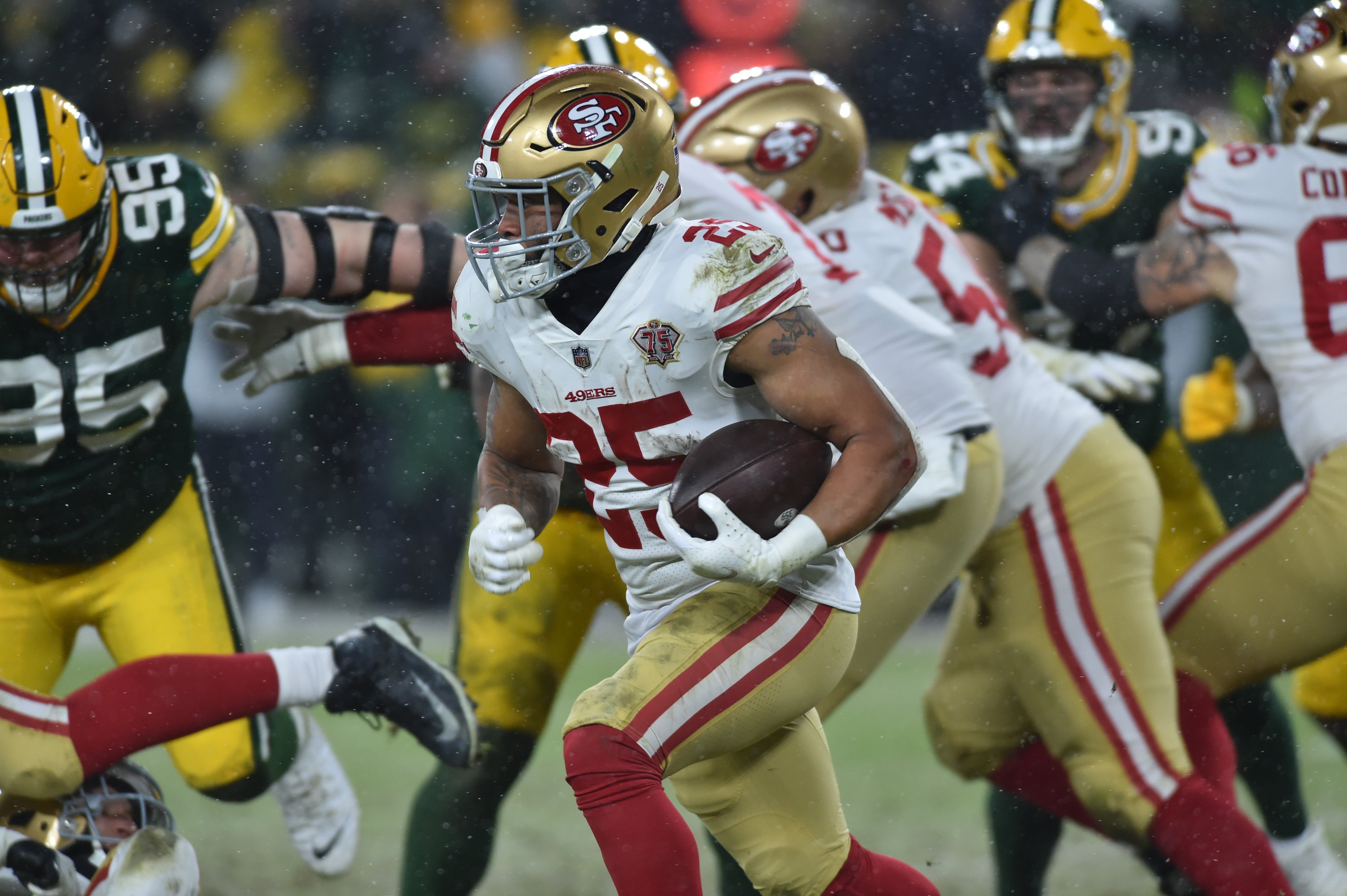 Jan 22, 2022; Green Bay, Wisconsin, USA; San Francisco 49ers running back Elijah Mitchell (25) runs the ball in the fourth quarter against the Green Bay Packers during a NFC Divisional playoff football game at Lambeau Field.