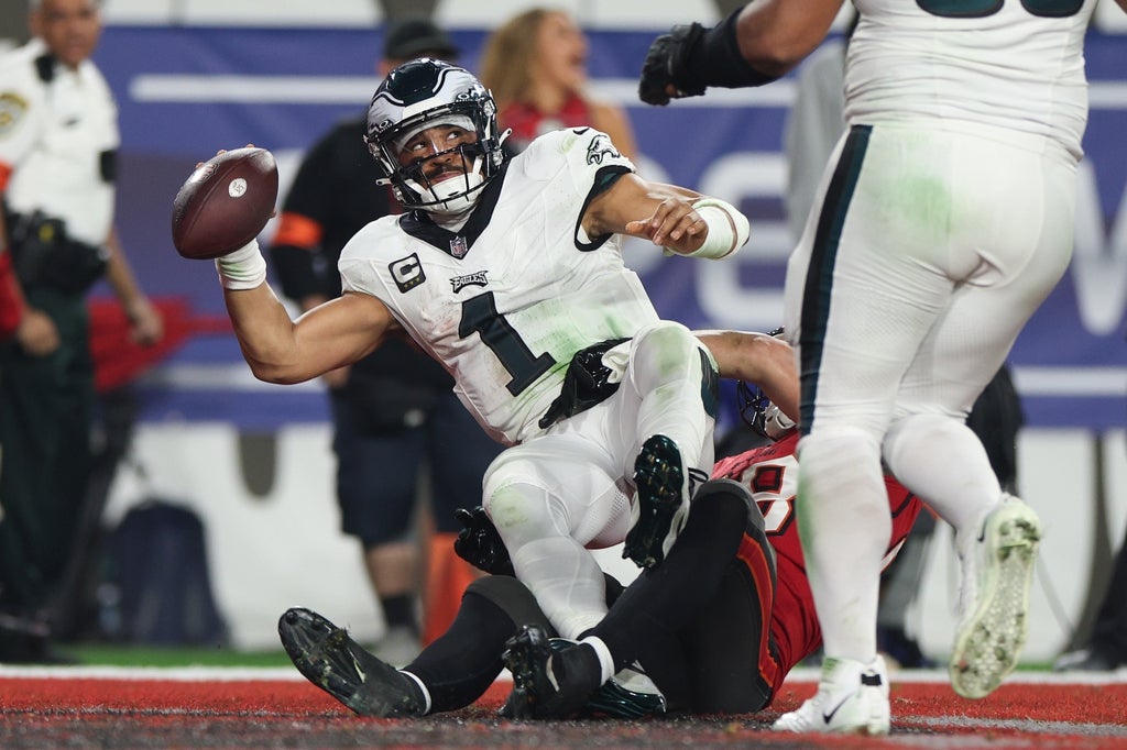 Tampa Bay Buccaneers linebacker Anthony Nelson (98) tackles Philadelphia Eagles quarterback Jalen Hurts (1) for a safety during the second half of a 2024 NFC wild card game at Raymond James Stadium.